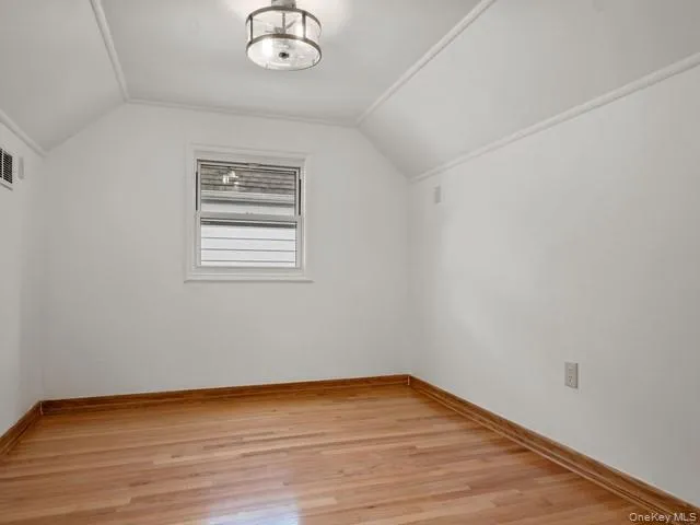 Bonus room with baseboards, light wood-style flooring, and vaulted ceiling Bonus room with baseboards, light wood-style flooring, and vaulted ceiling