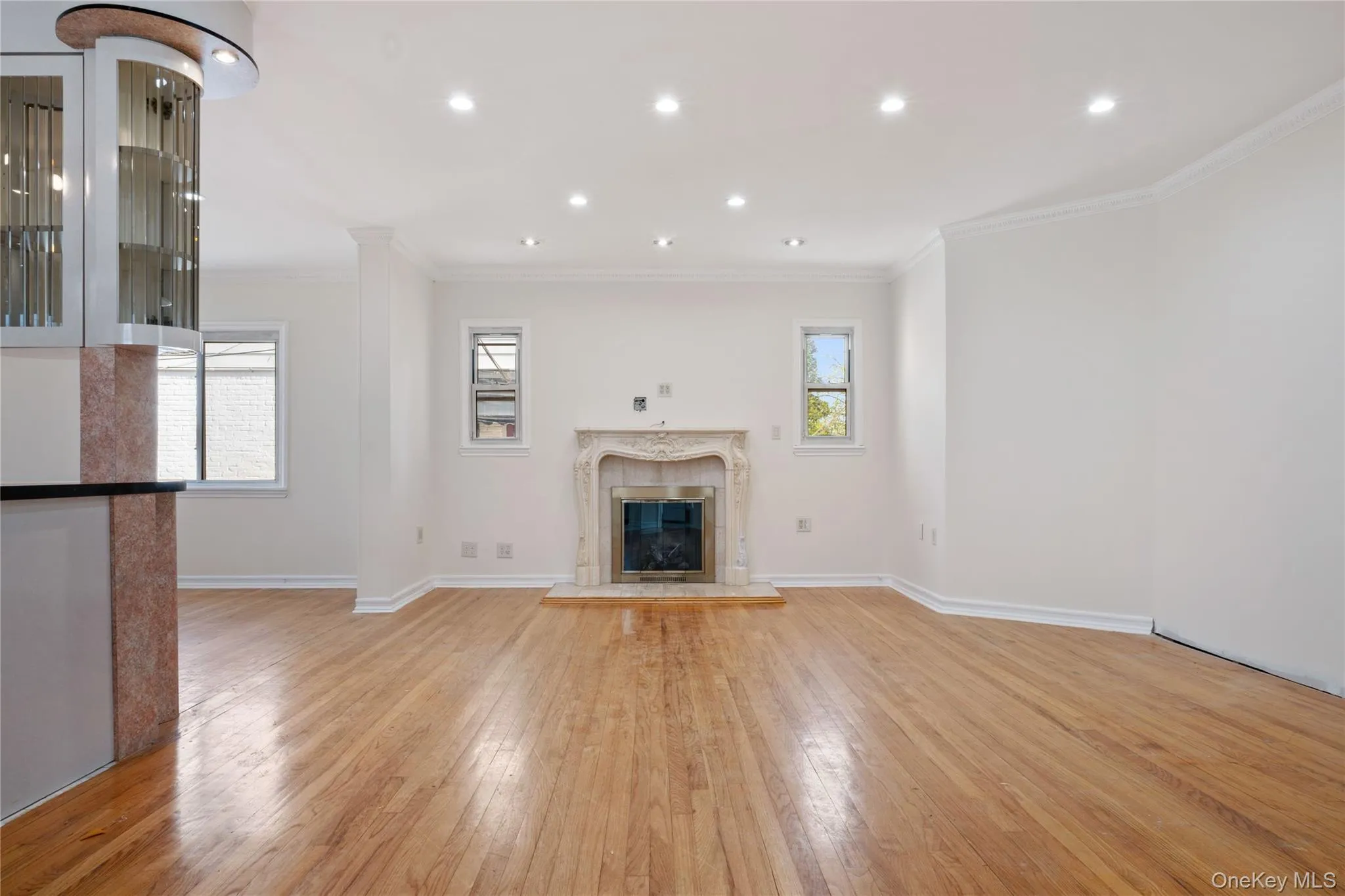 Unfurnished living room featuring crown molding, a high end fireplace, light wood-style floors, baseboards, and recessed lighting Unfurnished living room featuring crown molding, a high end fireplace, light wood-style floors, baseboards, and recessed lighting