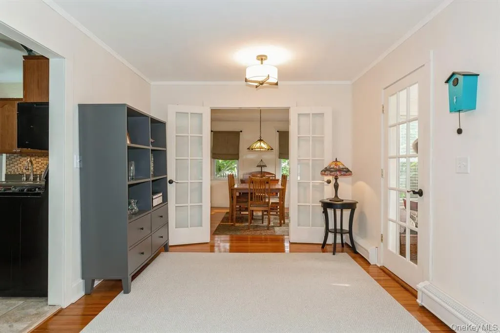 Sitting room with French doors, baseboard heating, light wood flooring Sitting room with French doors, baseboard heating, light wood flooring