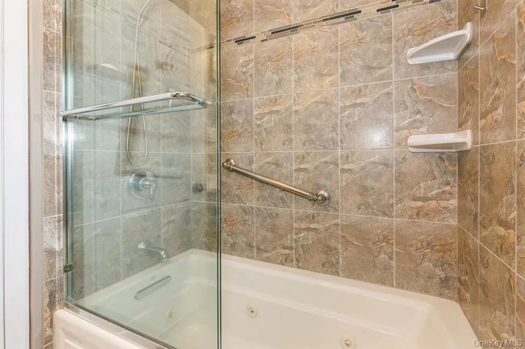 Bathroom with a combined bath/shower with jetted tub Bathroom with a combined bath/shower with jetted tub