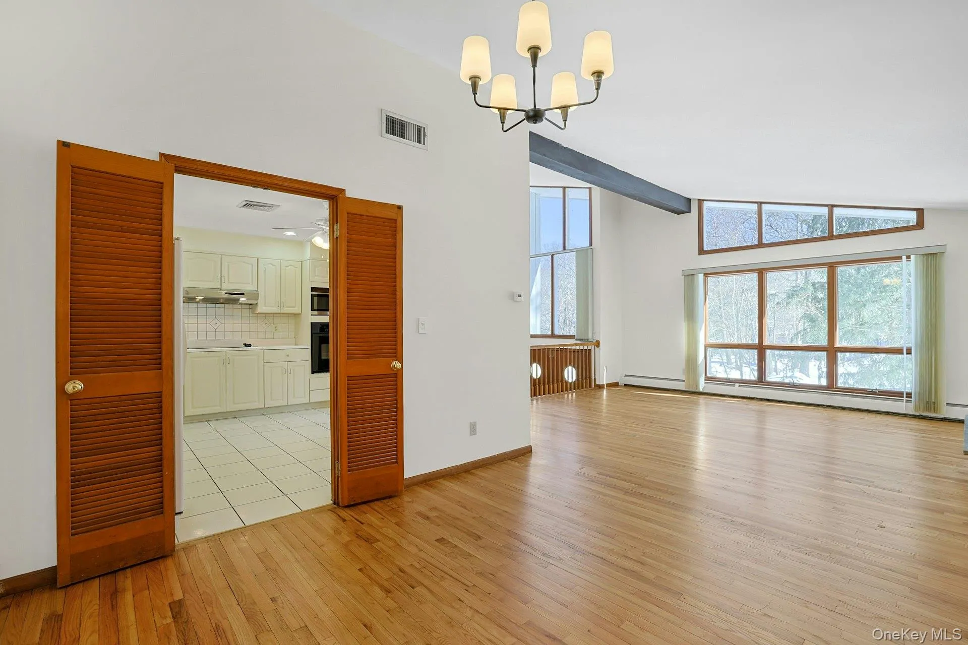 The dining room opens to the eat-in kitchen. From this angle we can see out to the huge wall of windows at the front of the home. The dining room opens to the eat-in kitchen. From this angle we can see out to the huge wall of windows at the front of the home.