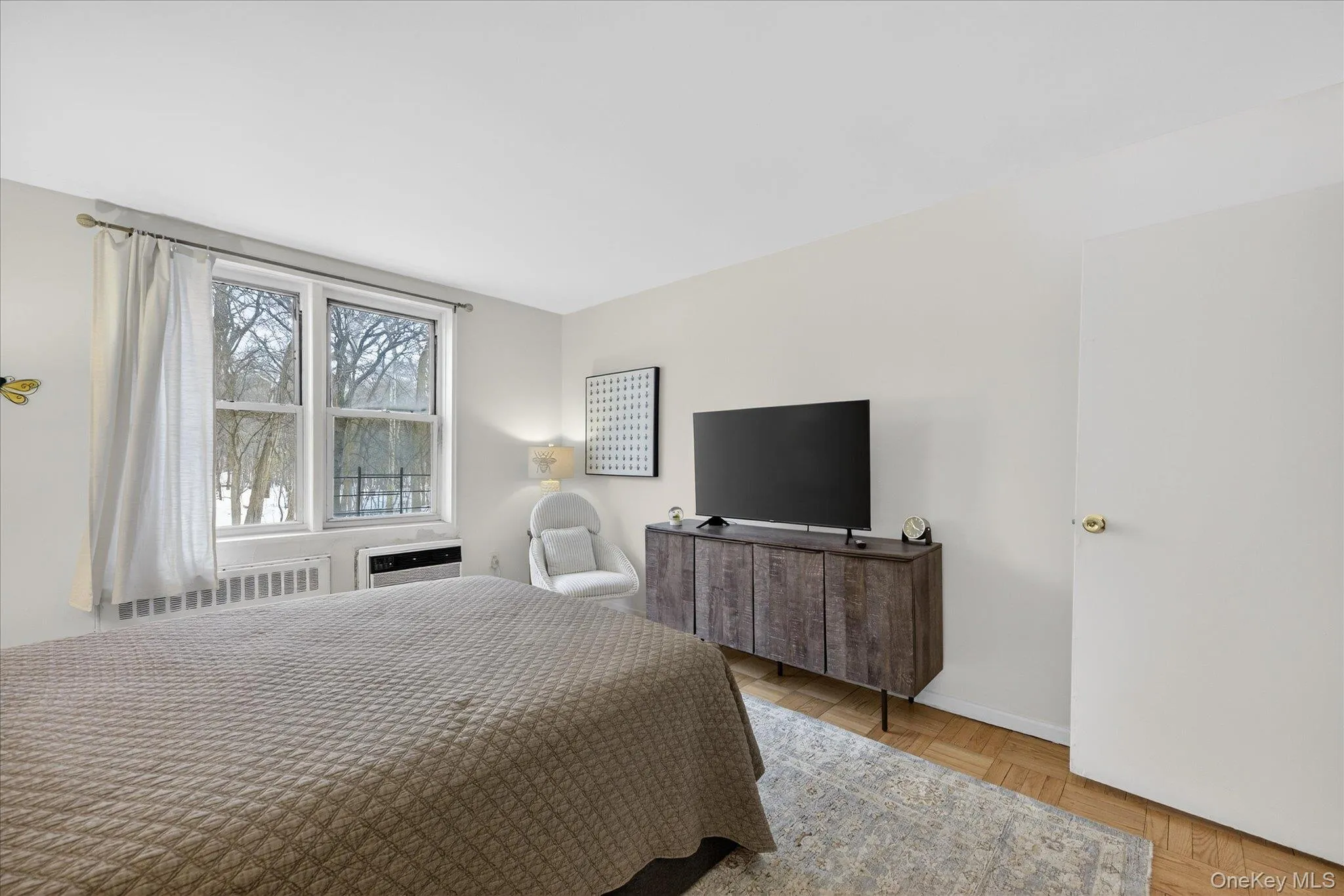 Bedroom featuring parquet flooring and radiator heating unit Bedroom featuring parquet flooring and radiator heating unit
