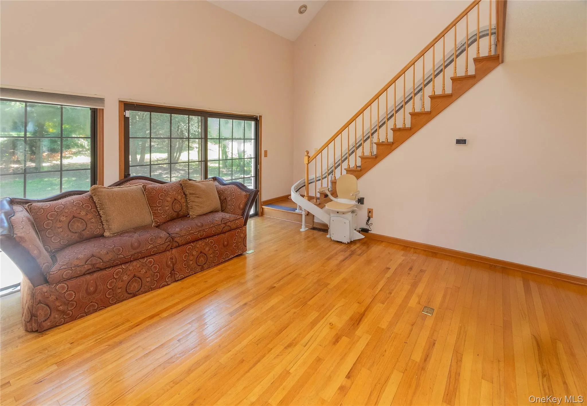 Living room featuring light wood-style floors and lofted ceiling Living room featuring light wood-style floors and lofted ceiling