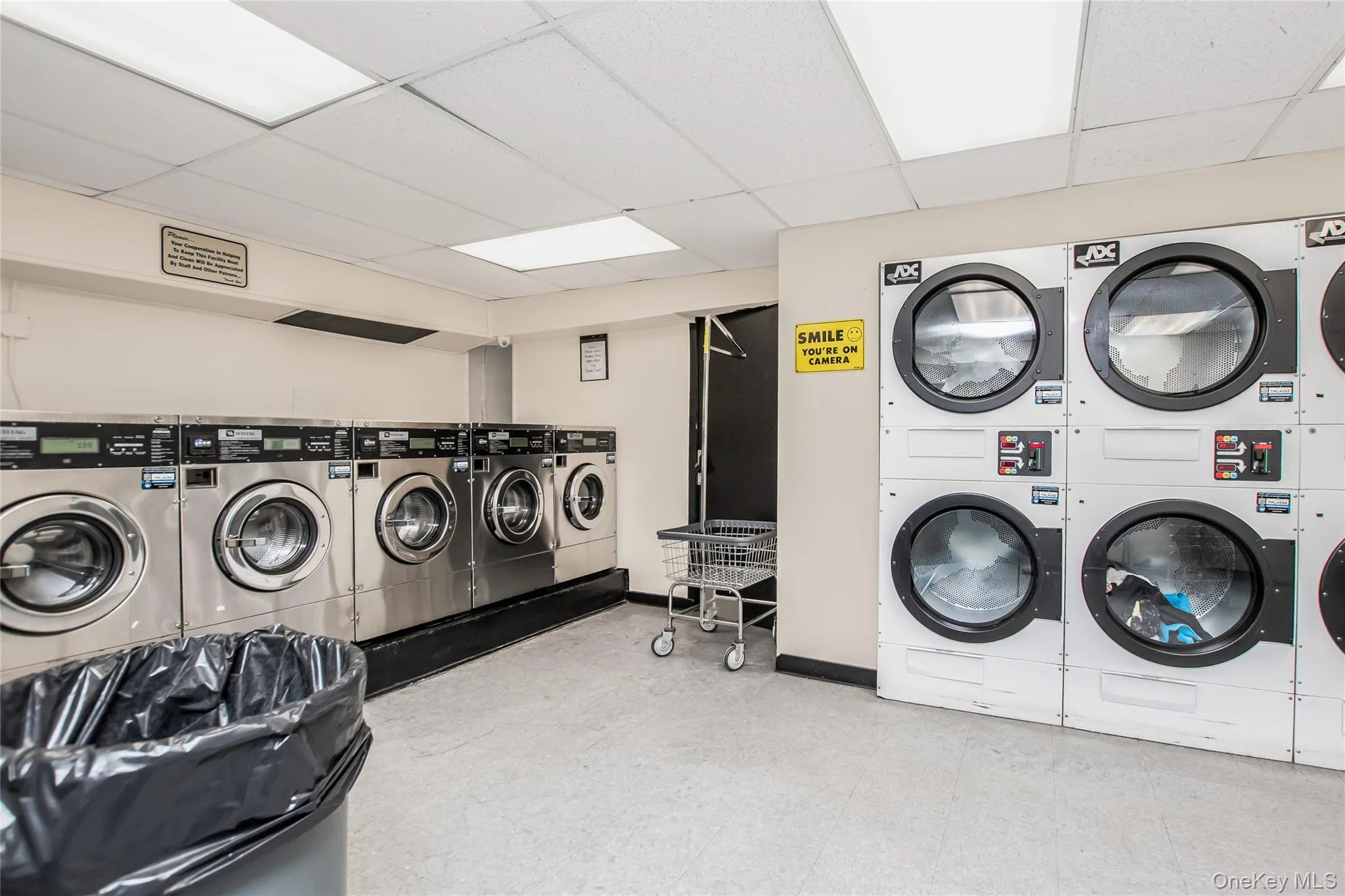 Communal laundry room with a paneled ceiling and separate washer and dryer Communal laundry room with a paneled ceiling and separate washer and dryer