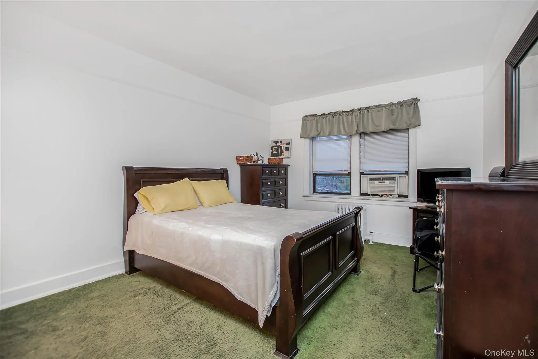 Bedroom with carpet, radiator heating unit, and cooling unit Bedroom with carpet, radiator heating unit, and cooling unit