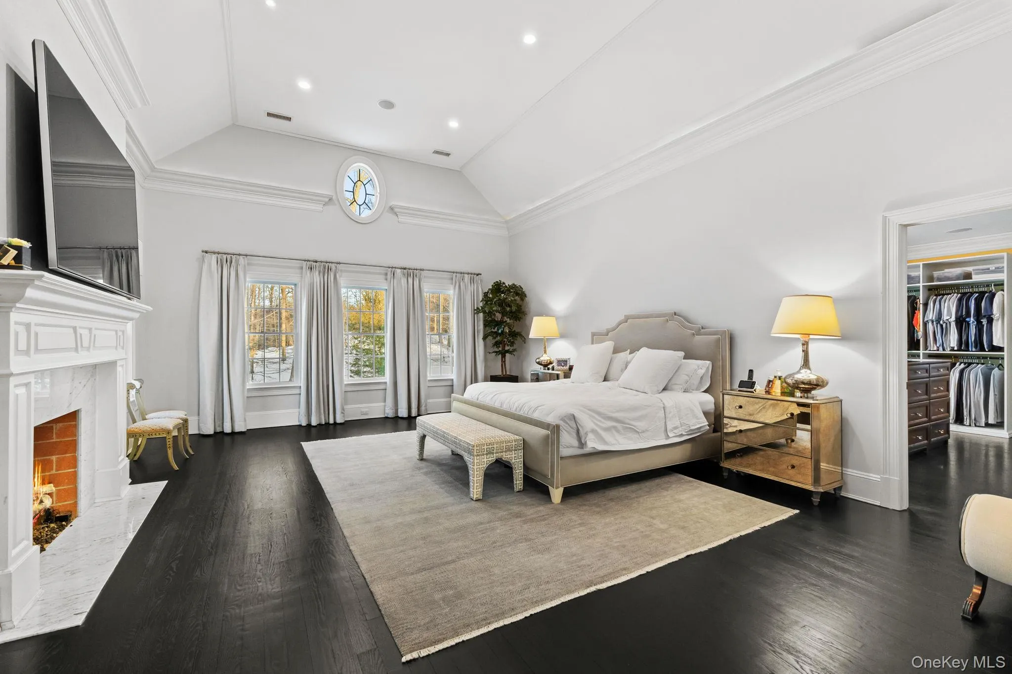A breathtaking bedroom, flooded with natural light from numerous windows, opens seamlessly to a private dressing room. A breathtaking bedroom, flooded with natural light from numerous windows, opens seamlessly to a private dressing room.