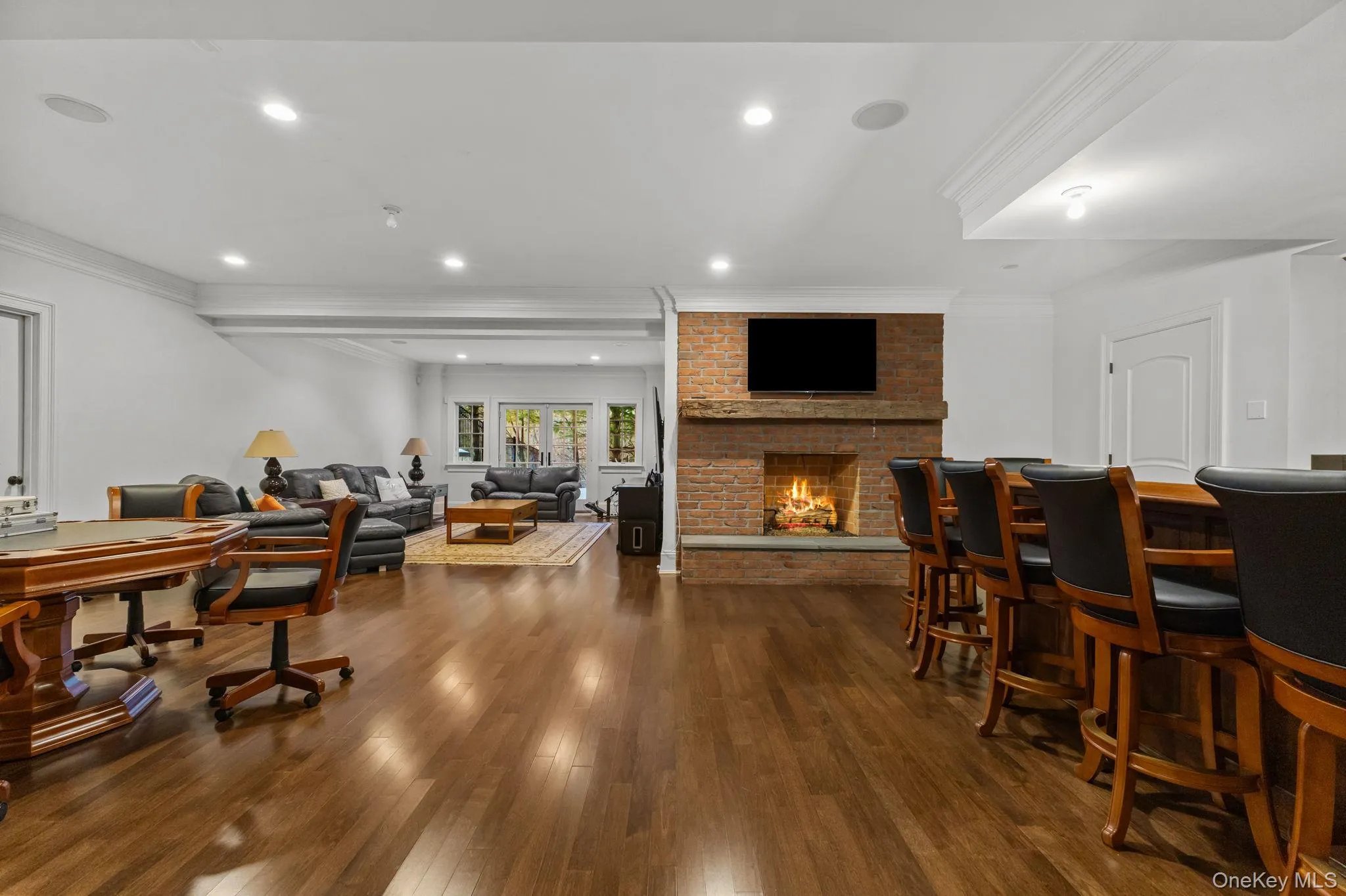 The Garden level is fully finished and opens directly to the yard, featuring a stunning fireplace, a custom-built bar with seating for eight, a poker area, gym, theater room, and two full bathrooms. The Garden level is fully finished and opens directly to the yard, featuring a stunning fireplace, a custom-built bar with seating for eight, a poker area, gym, theater room, and two full bathrooms.
