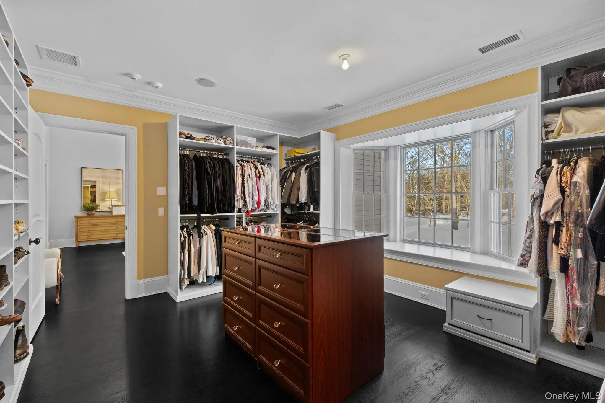 A truly impressive dressing room, featuring custom built-in shelving and an additional walk-in closet tucked at the rear. A truly impressive dressing room, featuring custom built-in shelving and an additional walk-in closet tucked at the rear.