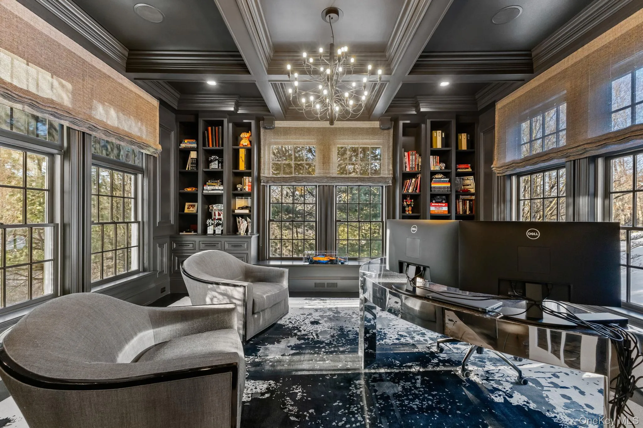 This library is destined to become your favorite retreat in the home. Tucked away behind stunning French doors, it offers a sense of privacy and refinement, enhanced by rich paneled walls and custom built-in cabinetry. Six oversized windows frame picturesque views of the side and rear grounds, while a dramatic coffered ceiling elevates the space, transporting you to another world. This library is destined to become your favorite retreat in the home. Tucked away behind stunning French doors, it offers a sense of privacy and refinement, enhanced by rich paneled walls and custom built-in cabinetry. Six oversized windows frame picturesque views of the side and rear grounds, while a dramatic coffered ceiling elevates the space, transporting you to another world.