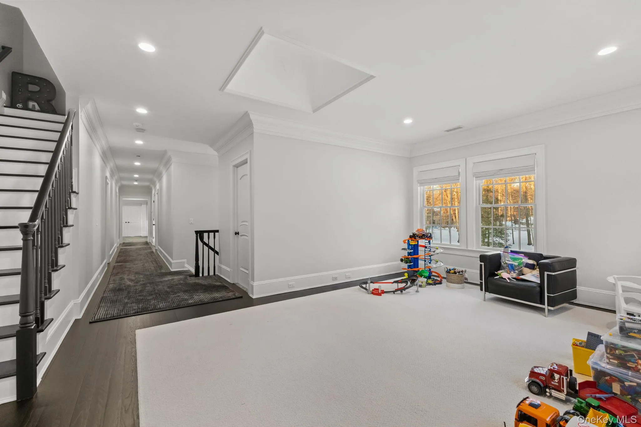 The open loft is ideal as an upper-level playroom, offering the perfect setting for family fun, toys, games, and after-dinner activities. A fully equipped laundry room is conveniently located nearby, along with access to the walk-up attic. The open loft is ideal as an upper-level playroom, offering the perfect setting for family fun, toys, games, and after-dinner activities. A fully equipped laundry room is conveniently located nearby, along with access to the walk-up attic.