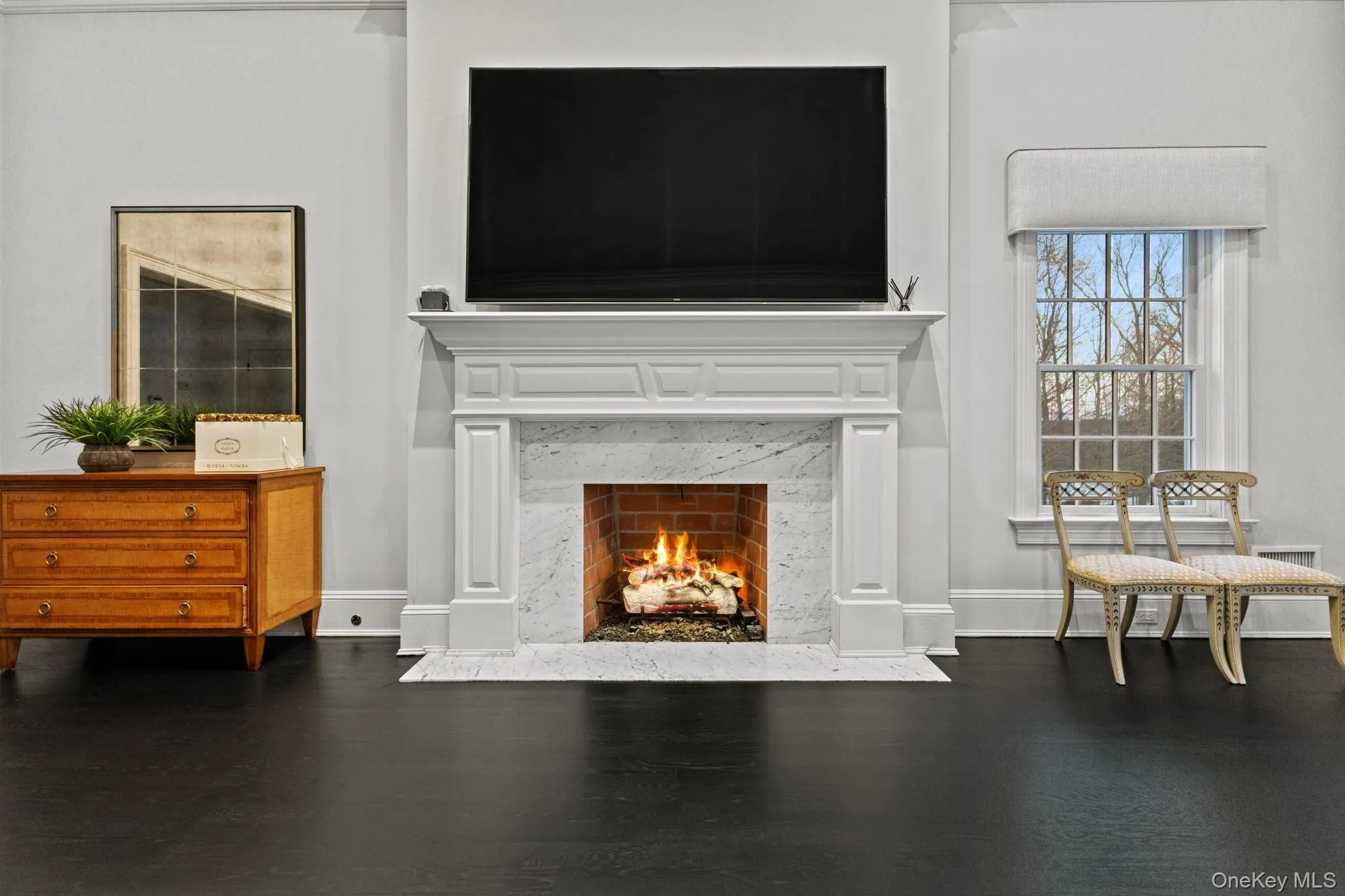 A stunning marble-surround fireplace warms both the room and the heart, complemented by a vaulted tray ceiling with elegant cove lighting. A stunning marble-surround fireplace warms both the room and the heart, complemented by a vaulted tray ceiling with elegant cove lighting.