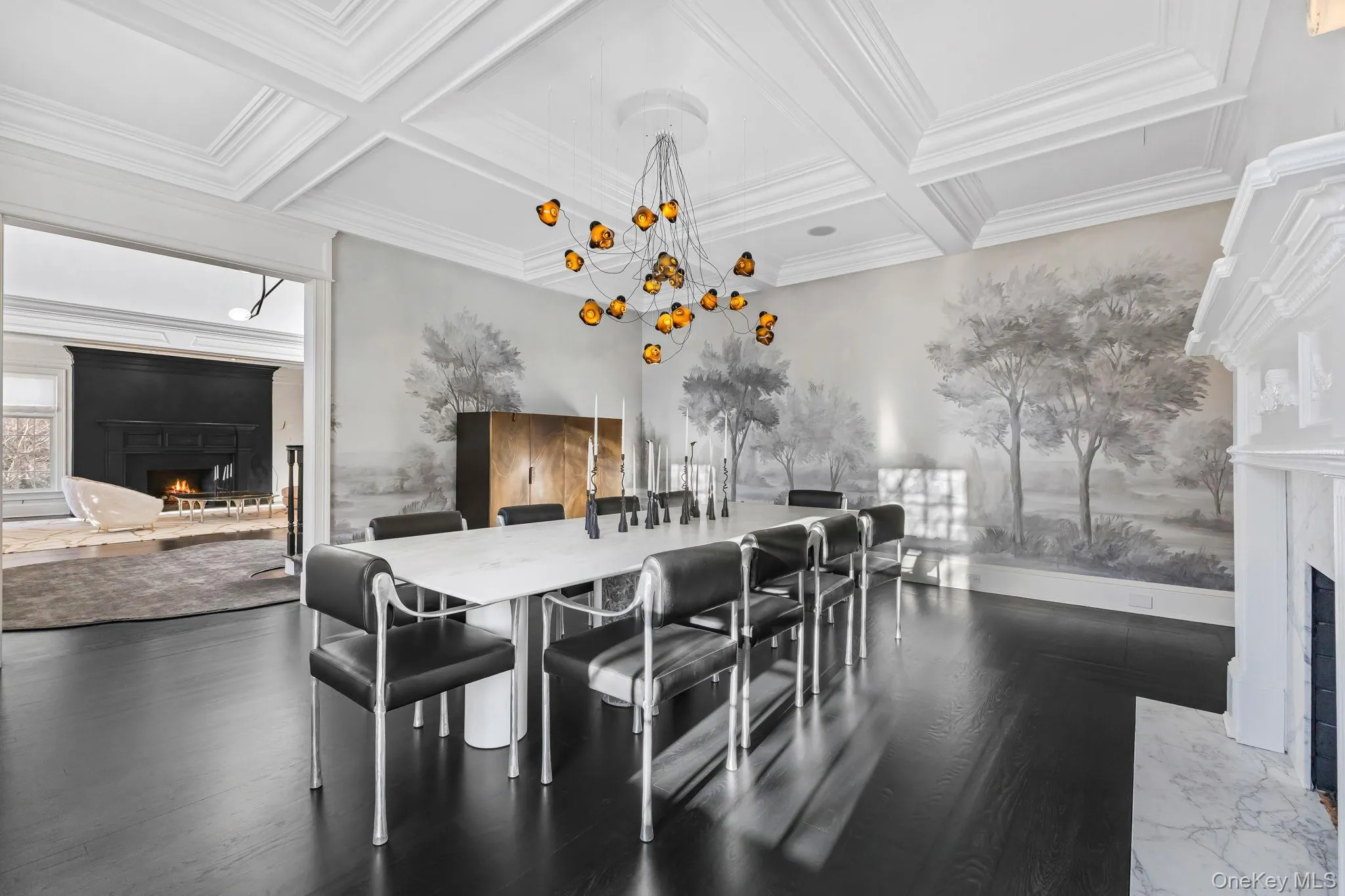 An inviting, sun-drenched dining room, generously proportioned and beautifully appointed, features a wide, columned entry, a coffered ceiling with recessed lighting, and a magnificent fireplace that adds an extra touch of warmth and charm. An inviting, sun-drenched dining room, generously proportioned and beautifully appointed, features a wide, columned entry, a coffered ceiling with recessed lighting, and a magnificent fireplace that adds an extra touch of warmth and charm.