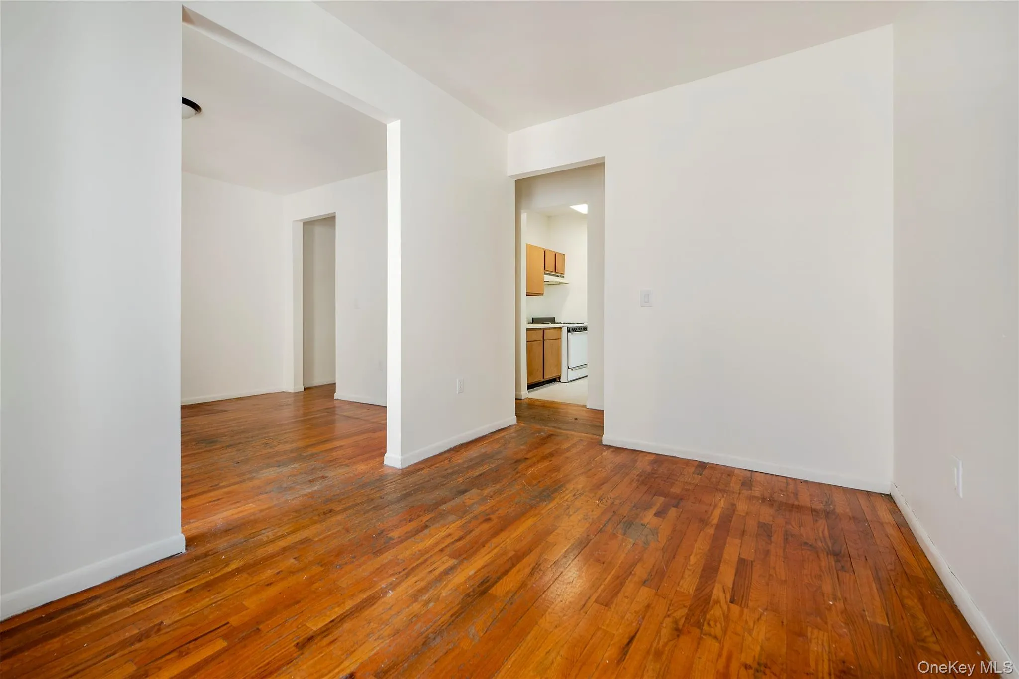 Unfurnished dining room featuring dark wood finished floors view from living room Unfurnished dining room featuring dark wood finished floors view from living room