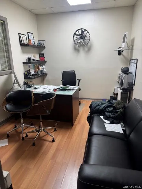 Home office featuring a drop ceiling and light wood-style floors Home office featuring a drop ceiling and light wood-style floors