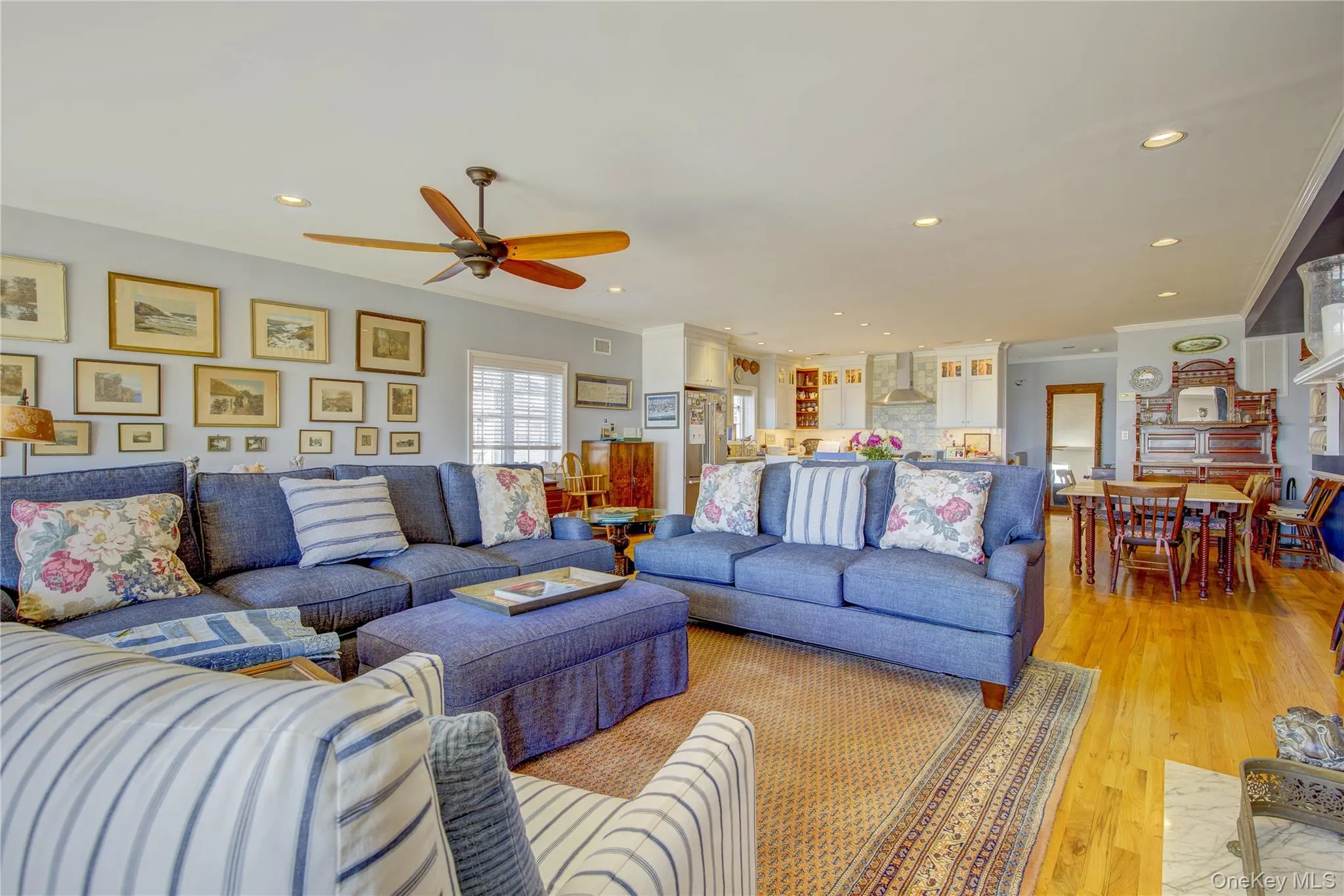 Living area featuring a ceiling fan, recessed lighting, ornamental molding, and light wood-type flooring Living area featuring a ceiling fan, recessed lighting, ornamental molding, and light wood-type flooring