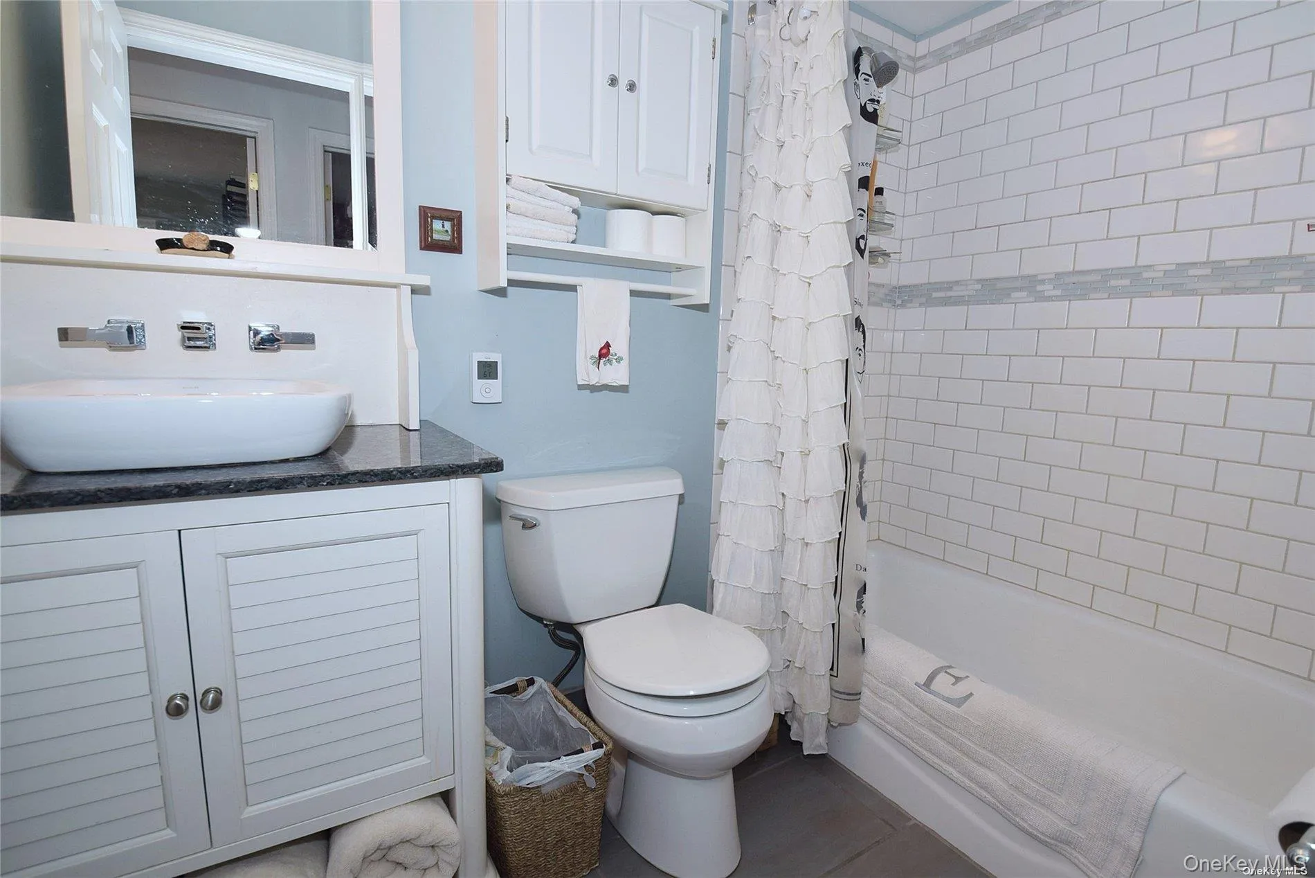 Full bathroom featuring vanity, shower / tub combo with curtain, and toilet Full bathroom featuring vanity, shower / tub combo with curtain, and toilet