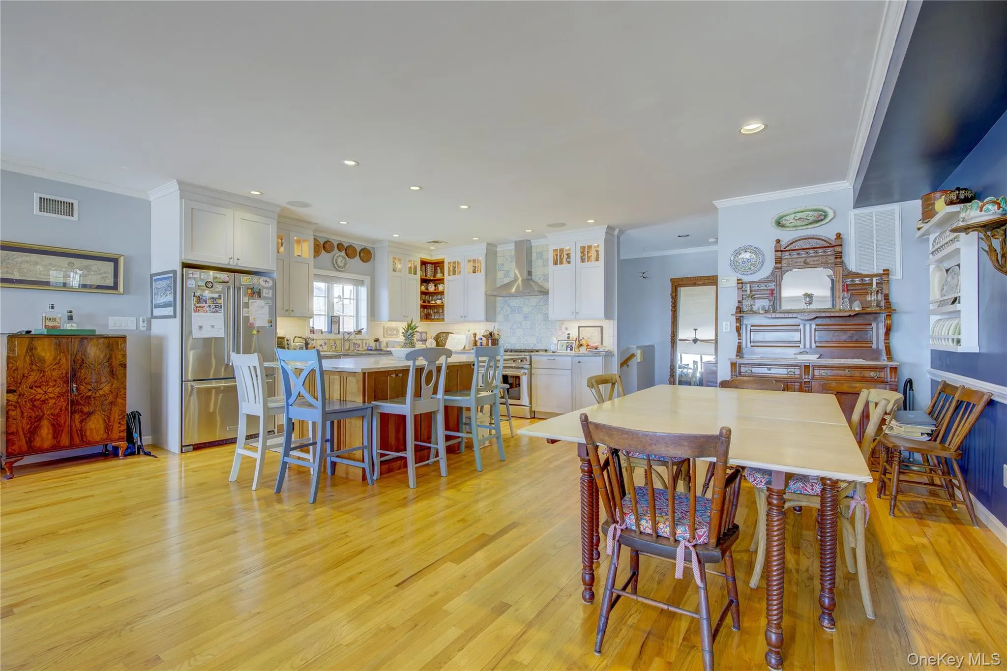 Dining room featuring light wood-style flooring, recessed lighting, crown molding, and visible vents Dining room featuring light wood-style flooring, recessed lighting, crown molding, and visible vents