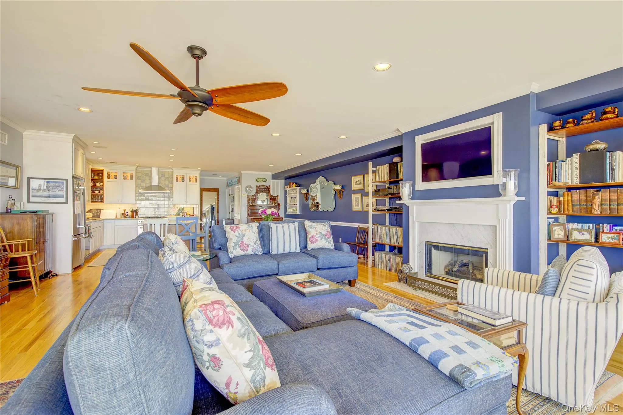 Living room featuring a fireplace, light wood-style flooring, ceiling fan, and recessed lighting Living room featuring a fireplace, light wood-style flooring, ceiling fan, and recessed lighting