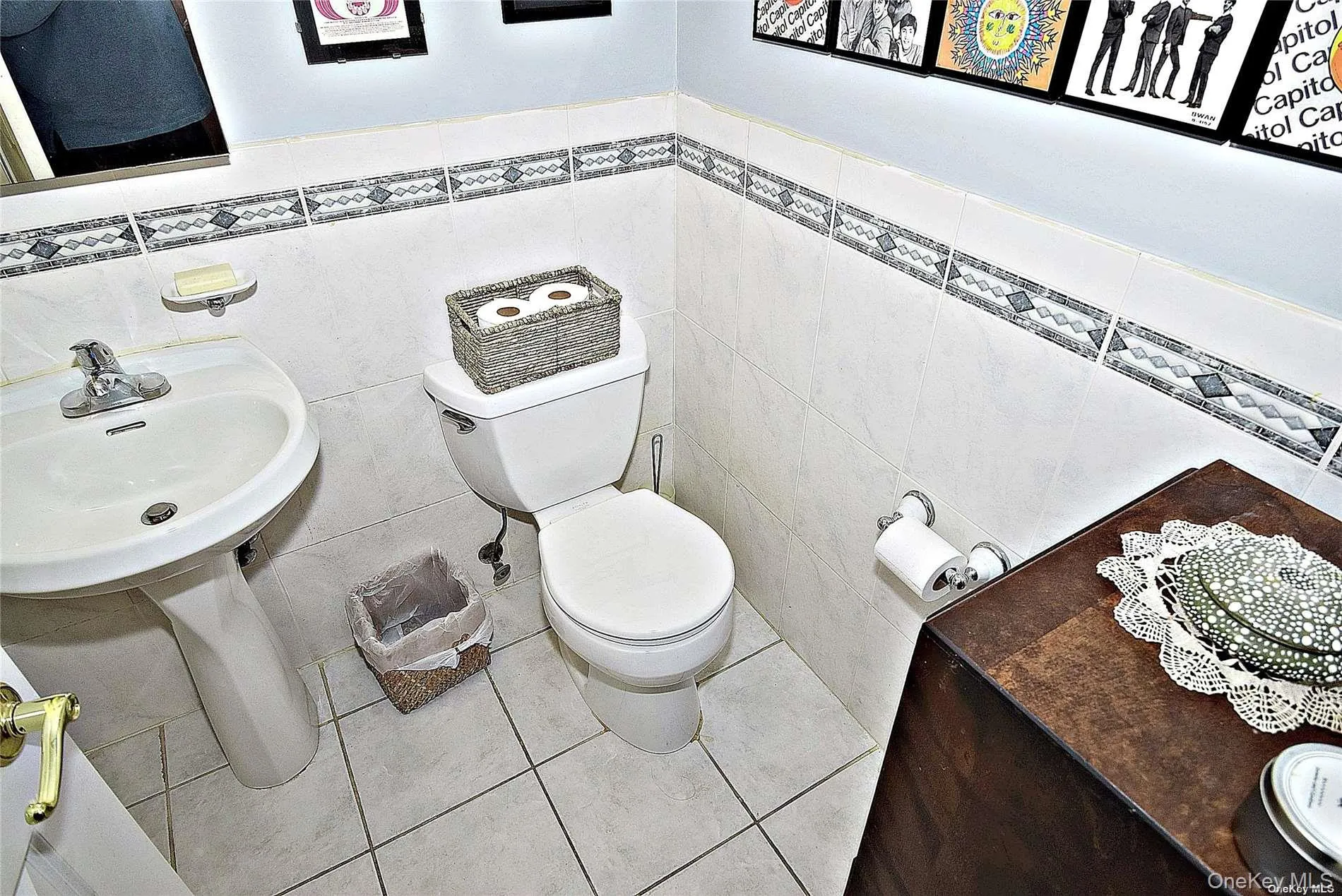 Bathroom with toilet, tile patterned flooring, sink, and tile walls Bathroom with toilet, tile patterned flooring, sink, and tile walls