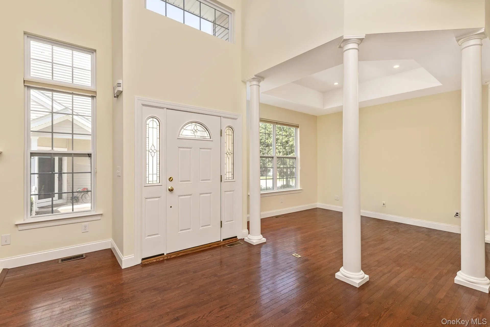 Two-story entryway featuring a decorative front door with sidelights, and transom windows Two-story entryway featuring a decorative front door with sidelights, and transom windows