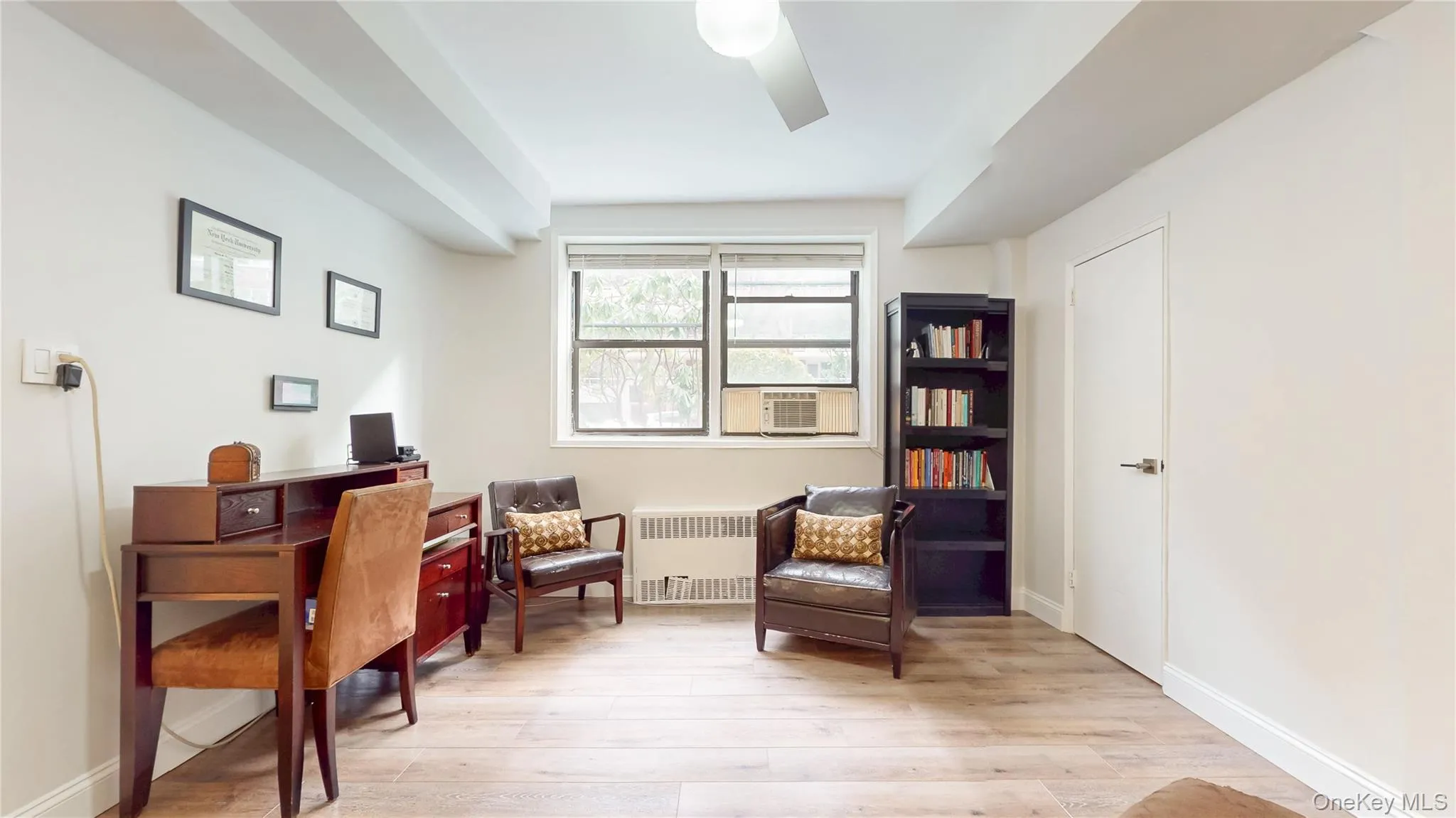 First office featuring radiator, a ceiling fan, and light wood-type flooring First office featuring radiator, a ceiling fan, and light wood-type flooring