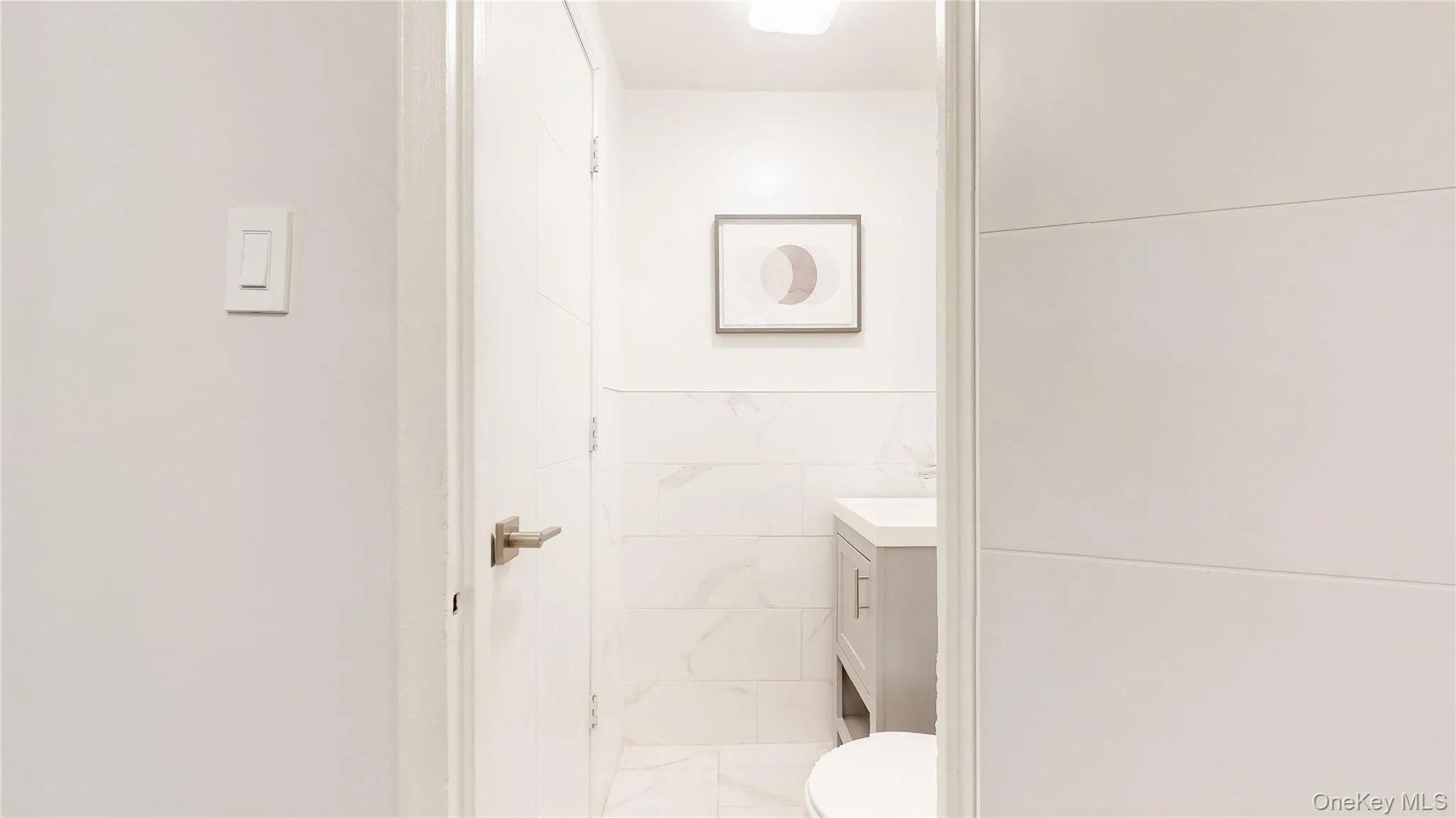 Half bathroom featuring vanity and tile walls Half bathroom featuring vanity and tile walls