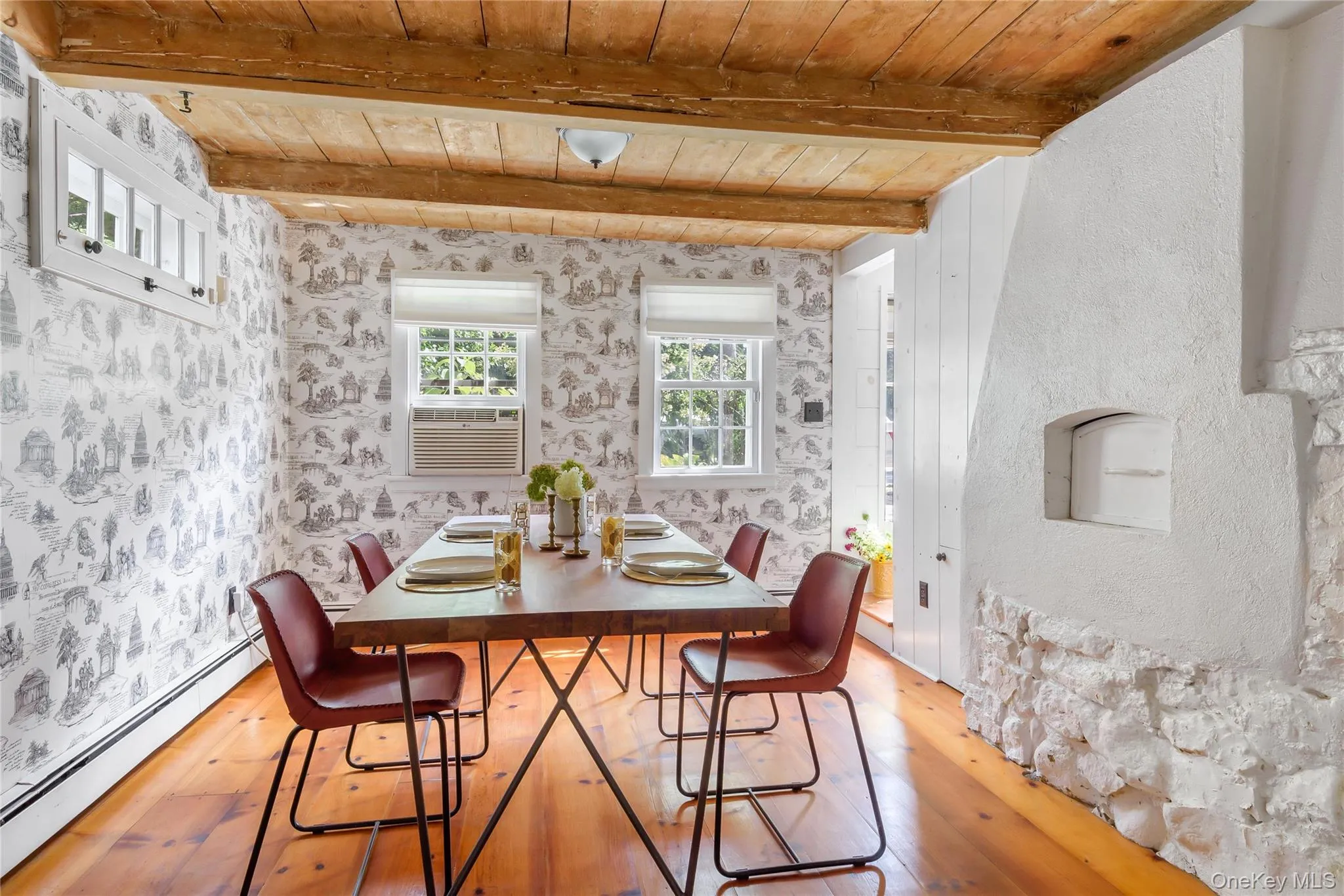 Dining area with a baseboard radiator, light wood-type flooring, and a wooden ceiling with exposed beams Dining area with a baseboard radiator, light wood-type flooring, and a wooden ceiling with exposed beams