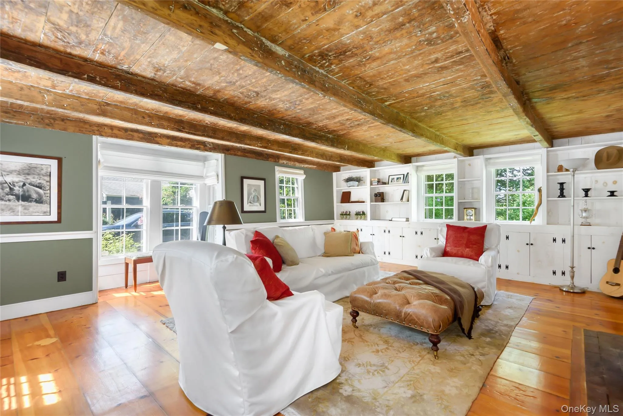 Living area with hardwood / wood-style floors, a wood ceiling with exposed beams, and plenty of natural light Living area with hardwood / wood-style floors, a wood ceiling with exposed beams, and plenty of natural light