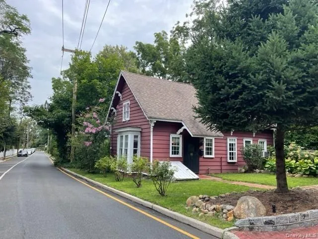 View of front of home with a shingled roof and a front yard View of front of home with a shingled roof and a front yard