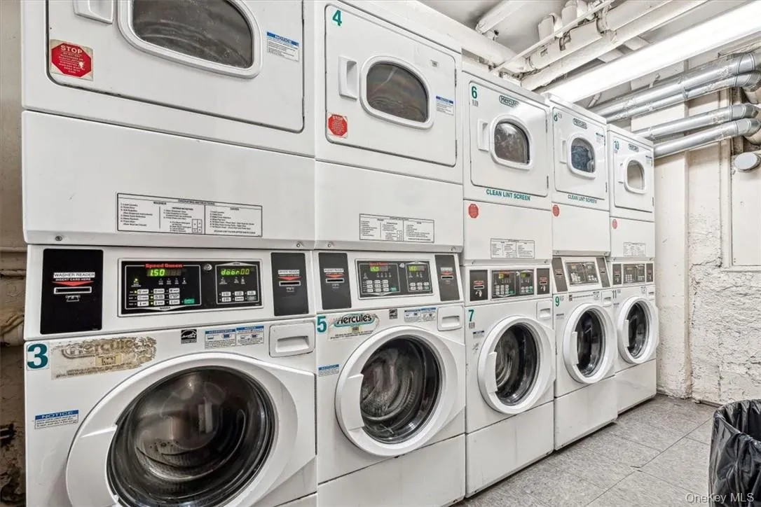 Laundry area featuring stacked washing maching and dryer, washing machine and clothes dryer, and light tile floors Laundry area featuring stacked washing maching and dryer, washing machine and clothes dryer, and light tile floors