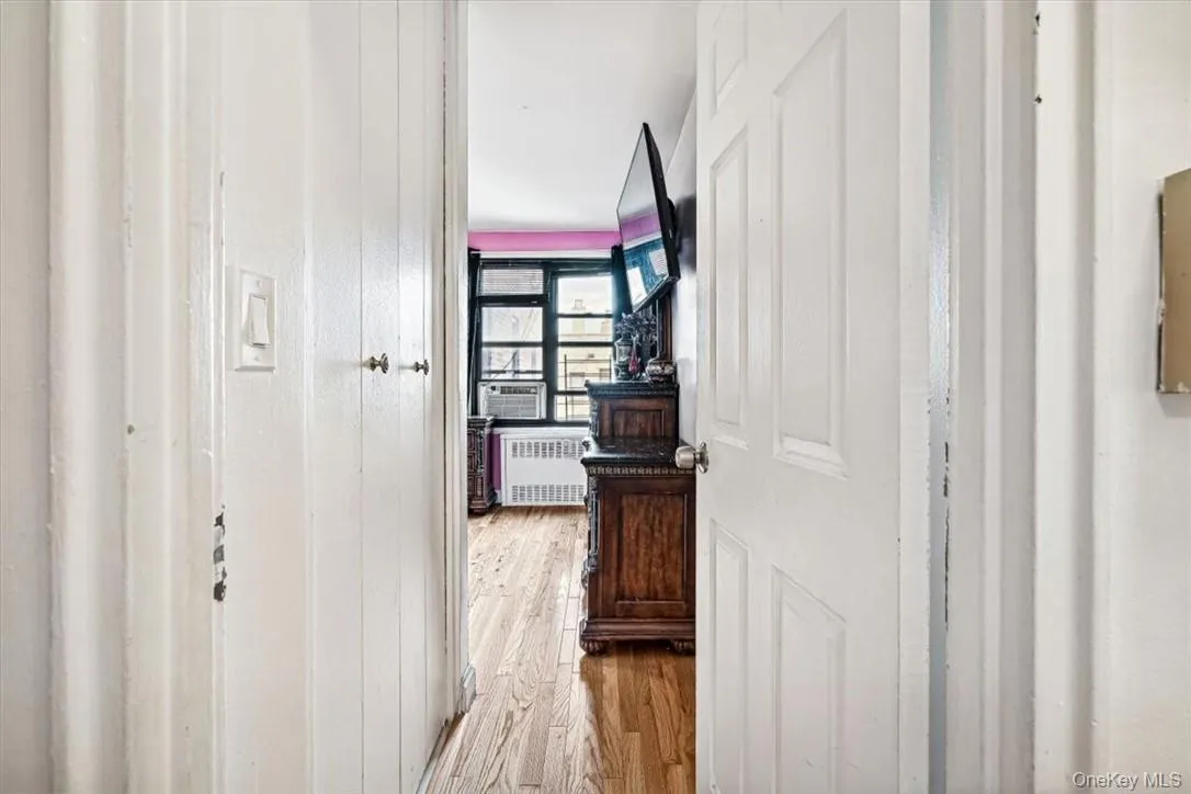 Hall with light hardwood / wood-style floors and radiator heating unit Hall with light hardwood / wood-style floors and radiator heating unit