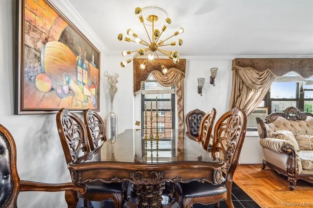 Dining room featuring plenty of natural light, ornamental molding, parquet floors, and a chandelier Dining room featuring plenty of natural light, ornamental molding, parquet floors, and a chandelier