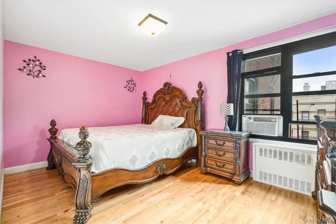 Bedroom with hardwood / wood-style floors and radiator Bedroom with hardwood / wood-style floors and radiator