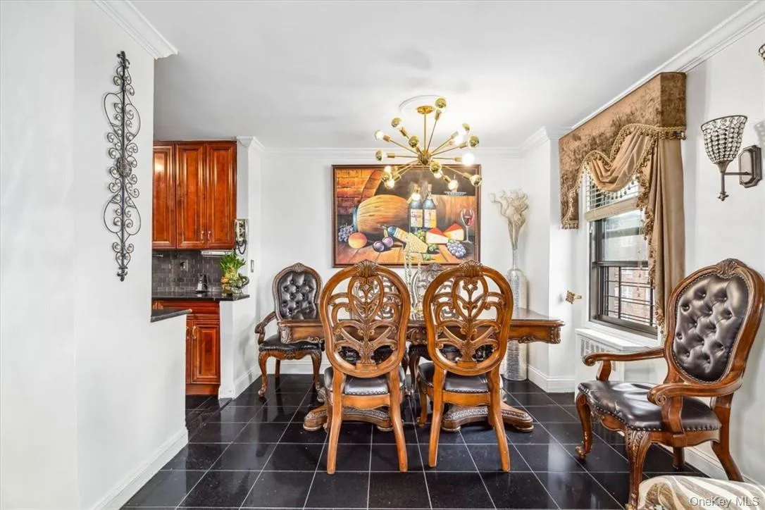 Tiled dining area with ornamental molding and an inviting chandelier Tiled dining area with ornamental molding and an inviting chandelier