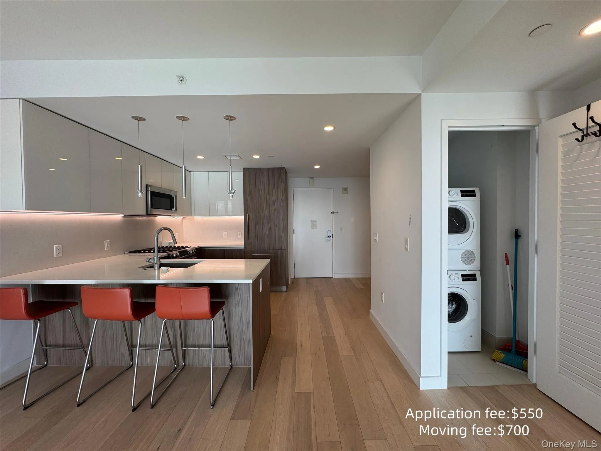 Kitchen featuring modern cabinets, a breakfast bar, light wood finished floors, a peninsula, and dual tone cabinets Kitchen featuring modern cabinets, a breakfast bar, light wood finished floors, a peninsula, and dual tone cabinets