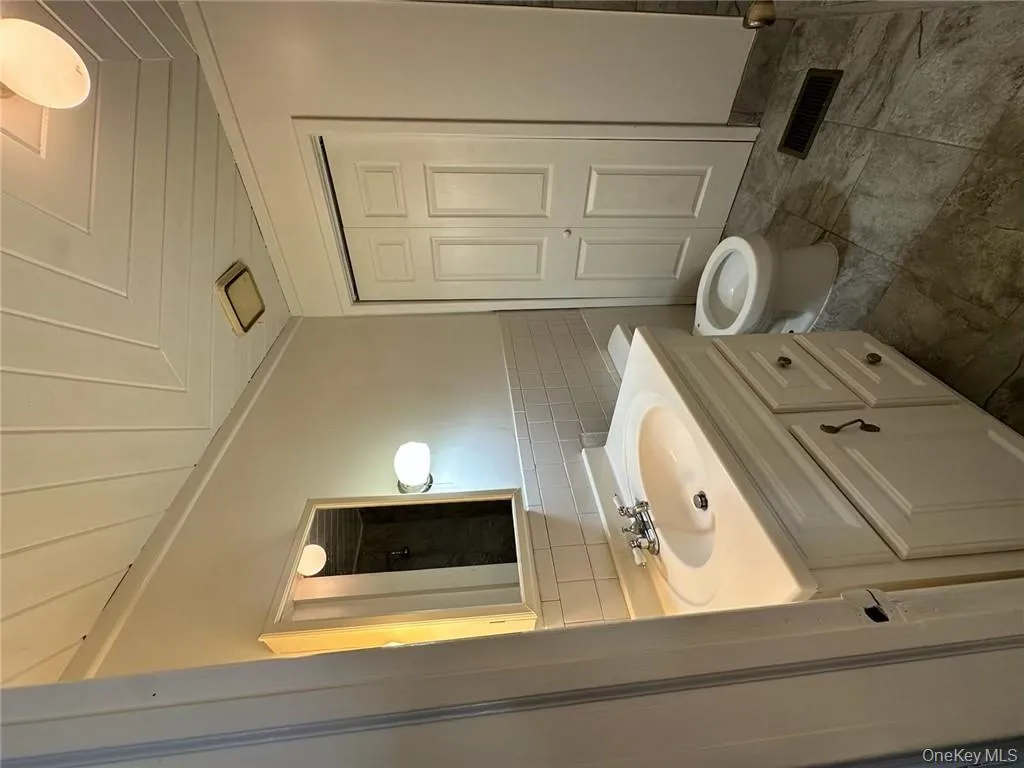 Bathroom featuring tile walls, toilet, wooden ceiling, and vanity Bathroom featuring tile walls, toilet, wooden ceiling, and vanity