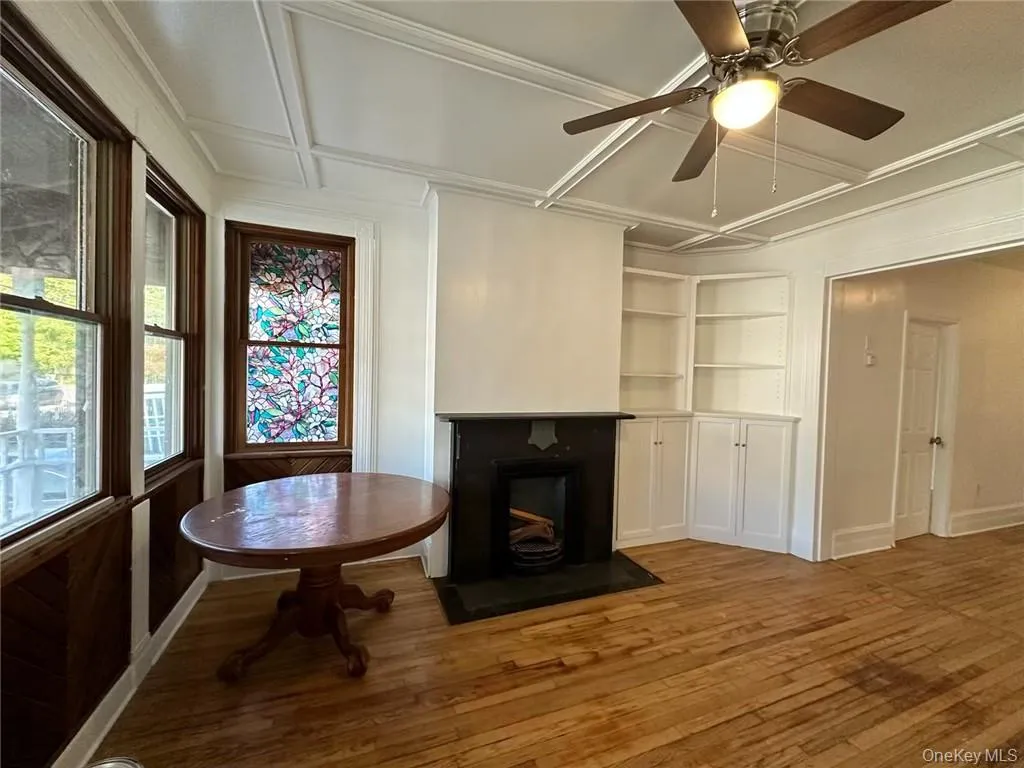 Entry way living room with built in shelves, hard wood floors, and plenty of natural light Entry way living room with built in shelves, hard wood floors, and plenty of natural light