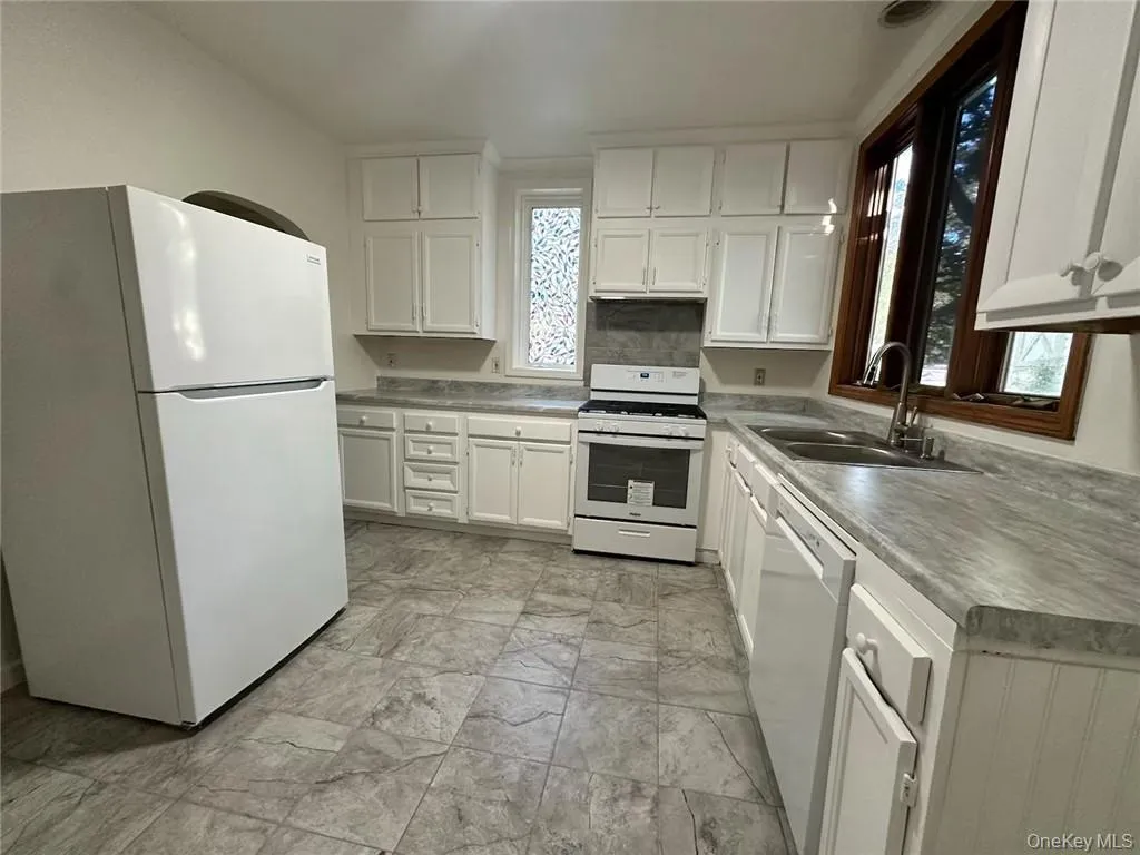 Kitchen with white cabinets, white appliances, and sink Kitchen with white cabinets, white appliances, and sink