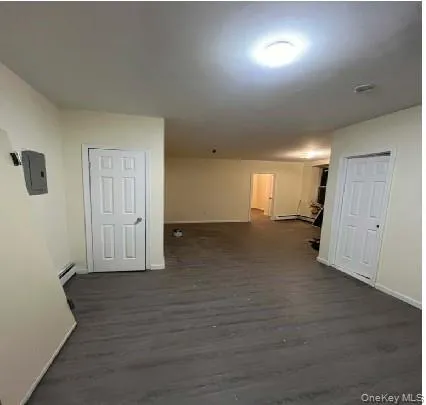 Hallway featuring dark hardwood / wood-style flooring, electric panel, and baseboard heating Hallway featuring dark hardwood / wood-style flooring, electric panel, and baseboard heating