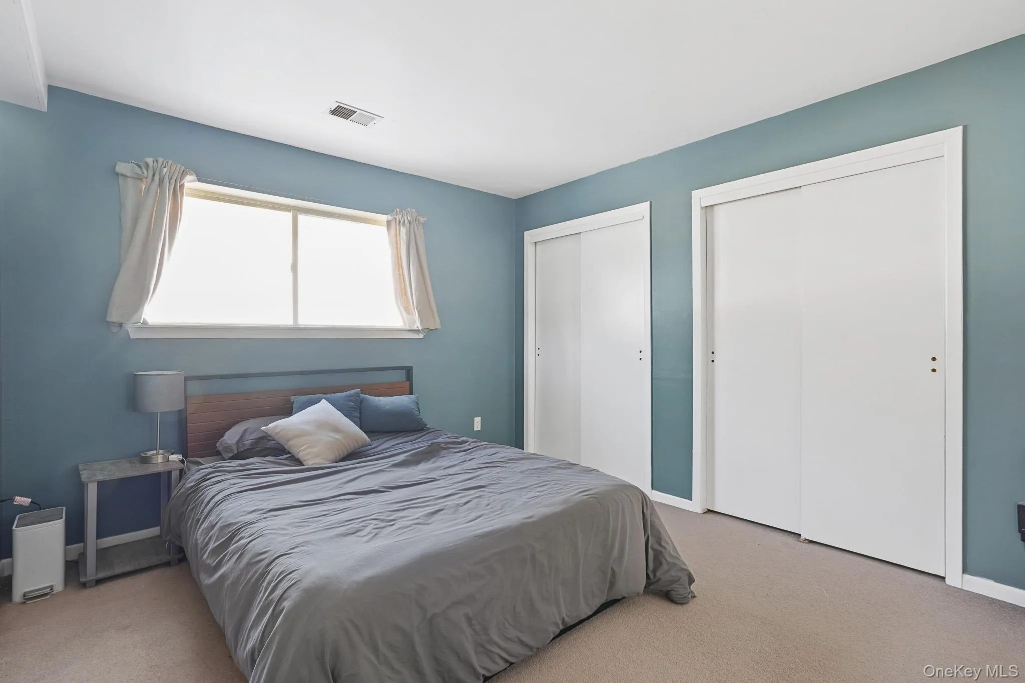 Bedroom featuring two closets and carpet Bedroom featuring two closets and carpet