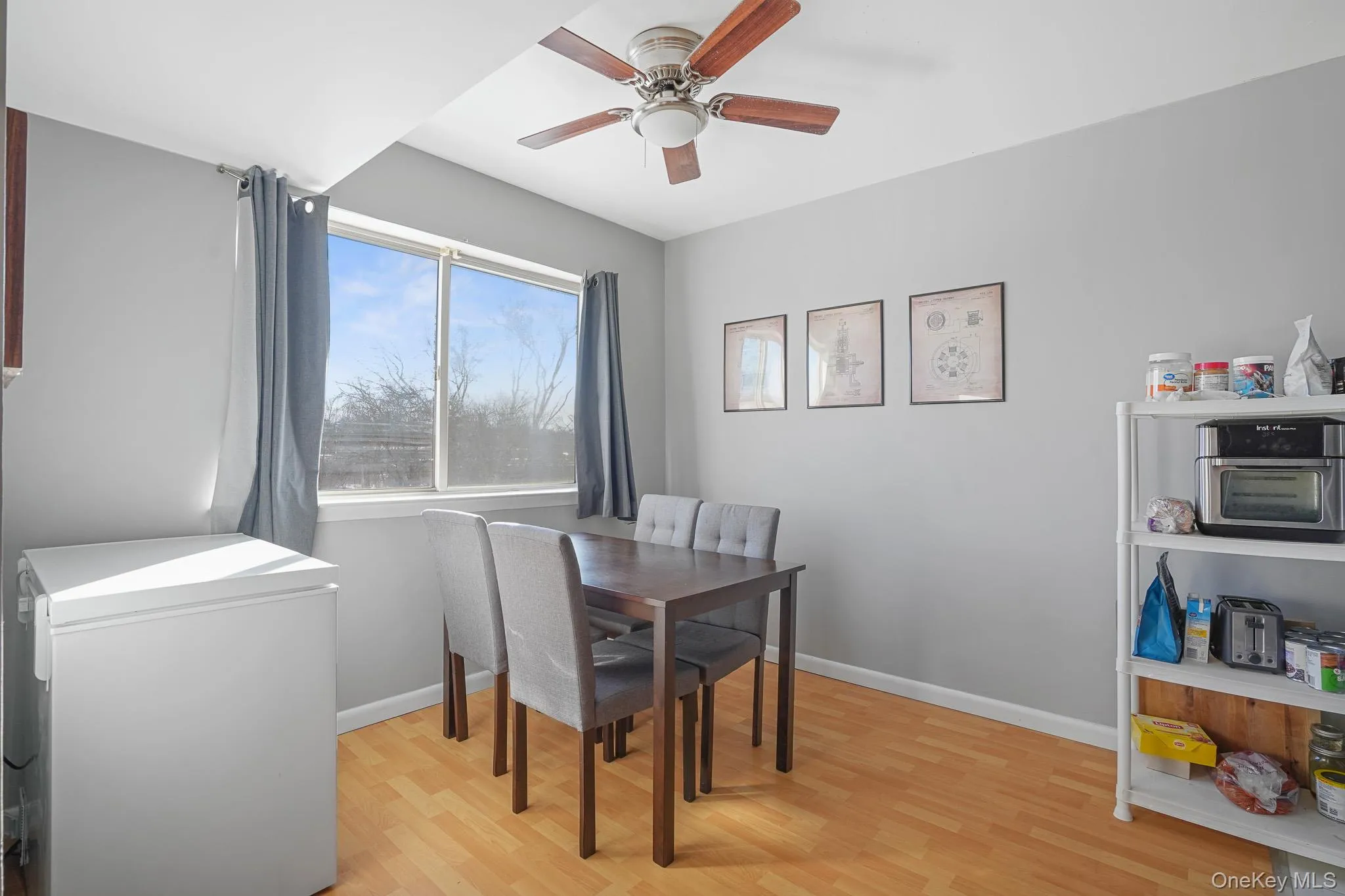 Dining room with light wood-type flooring and ceiling fan Dining room with light wood-type flooring and ceiling fan