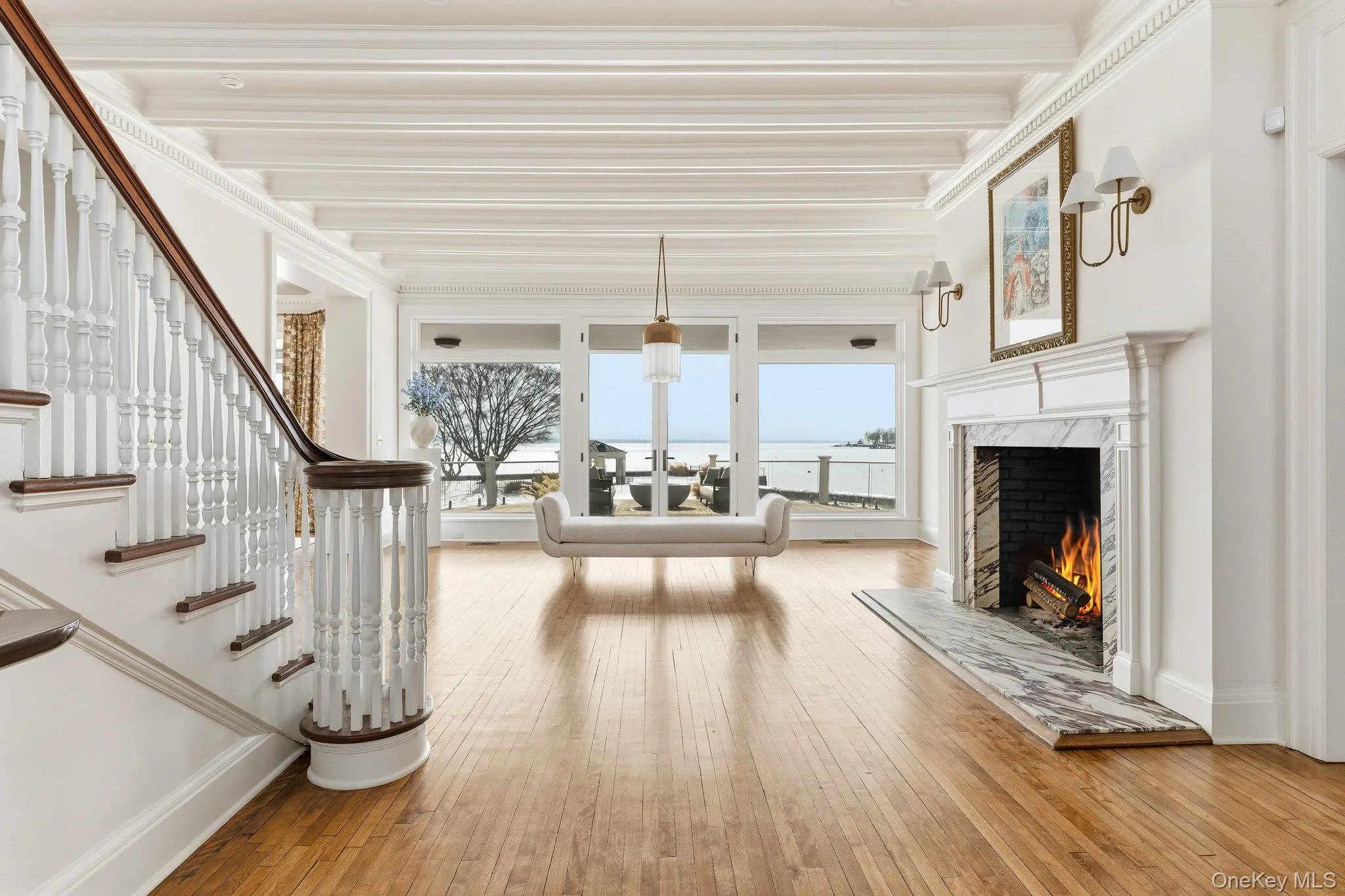 Living area with light wood-style flooring, a fireplace, and crown molding Living area with light wood-style flooring, a fireplace, and crown molding