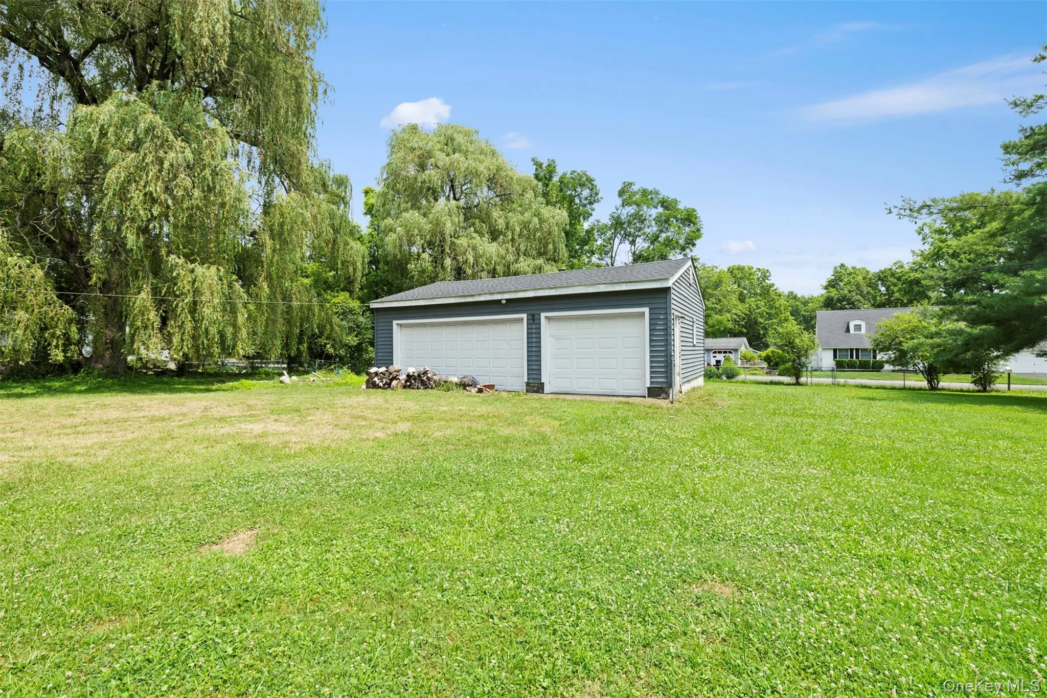 View of grassy yard featuring a garage and an outdoor structure View of grassy yard featuring a garage and an outdoor structure