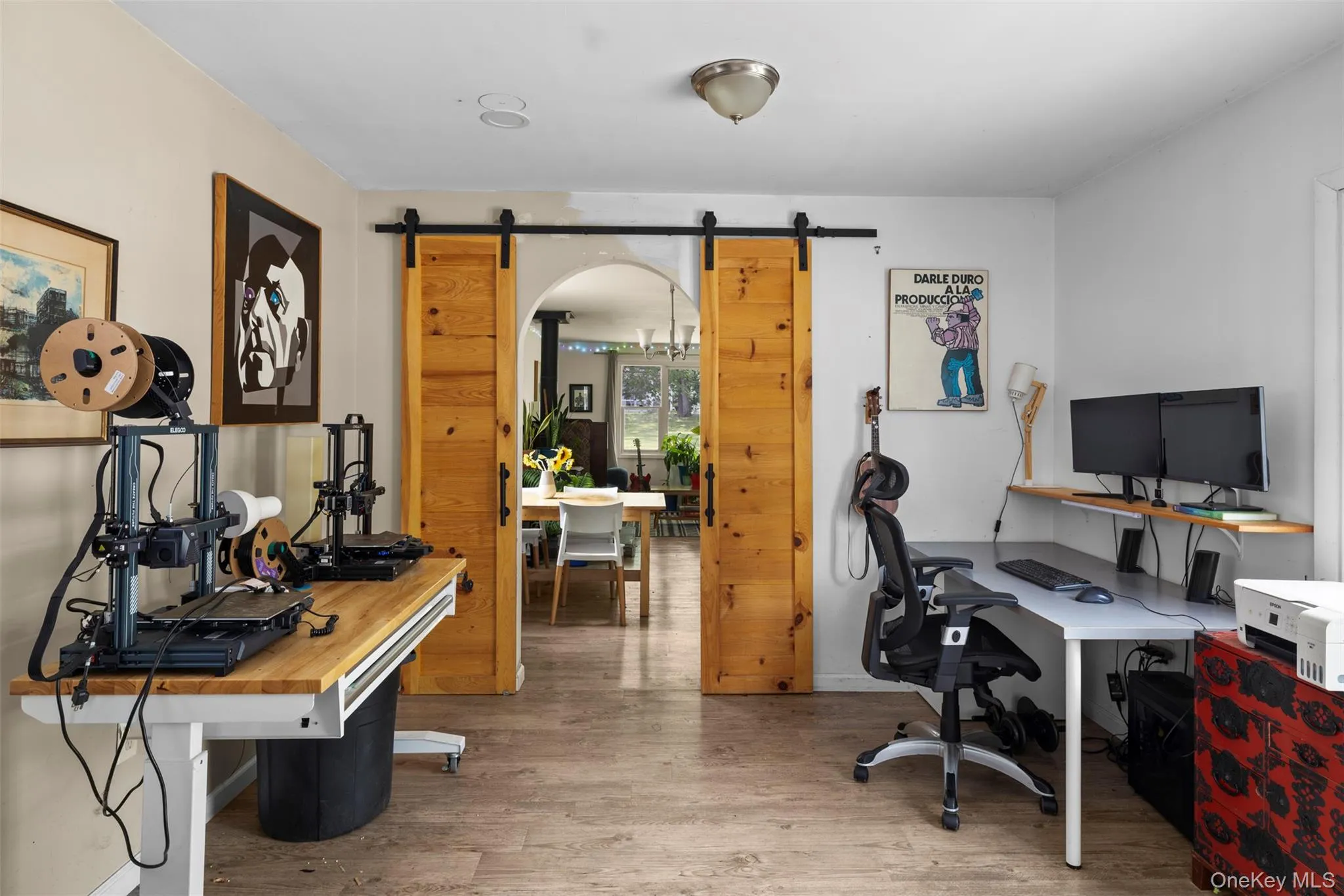 Office space featuring a barn door and wood finished floors Office space featuring a barn door and wood finished floors