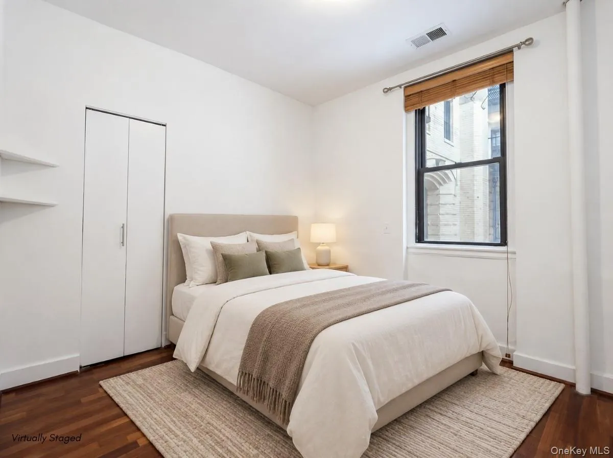 Hardwood flooring, crisp white walls, built-in shelving, and a double-door closet create a functional living space Hardwood flooring, crisp white walls, built-in shelving, and a double-door closet create a functional living space