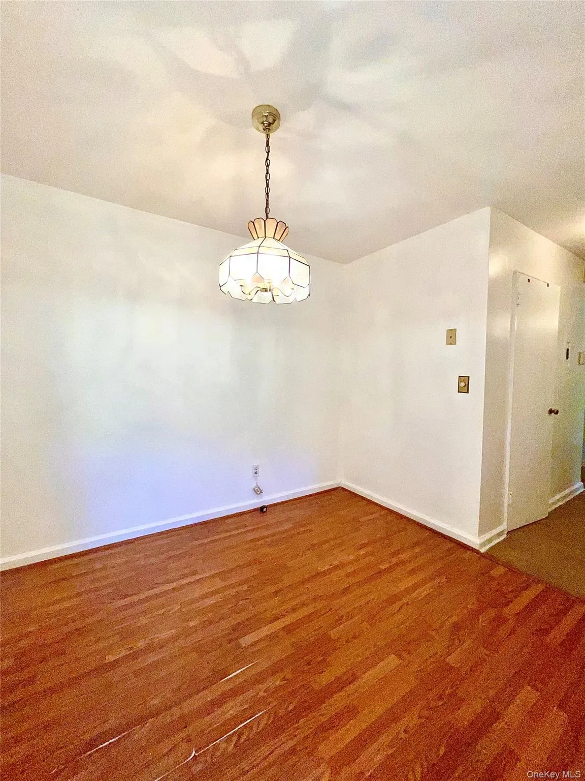 Unfurnished room with wood finished floors and baseboards Unfurnished room with wood finished floors and baseboards