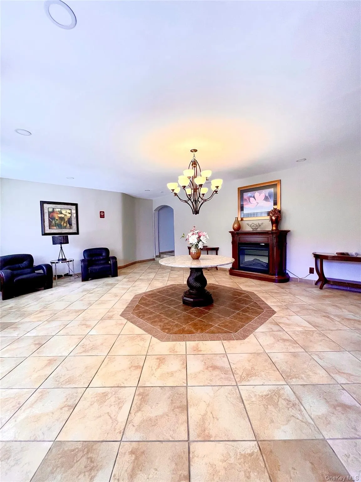 Dining area featuring a glass covered fireplace, a chandelier, and light tile patterned flooring Dining area featuring a glass covered fireplace, a chandelier, and light tile patterned flooring