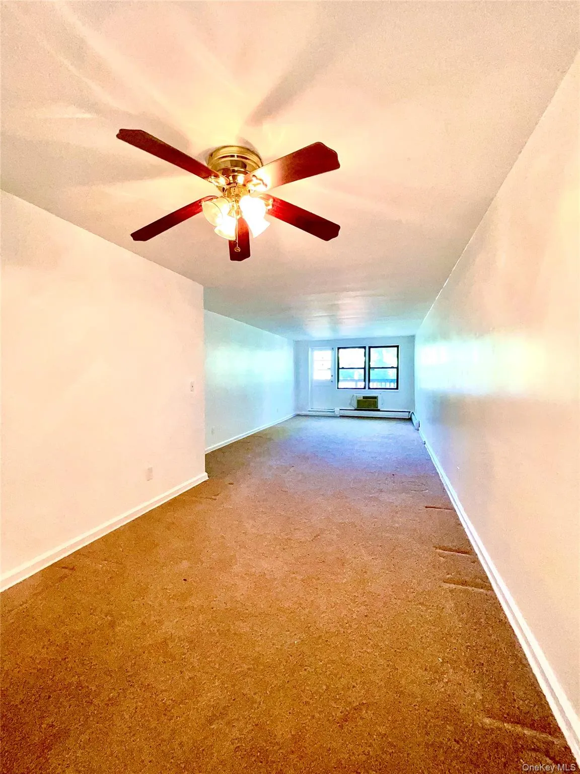 Unfurnished room with carpet and baseboards Unfurnished room with carpet and baseboards