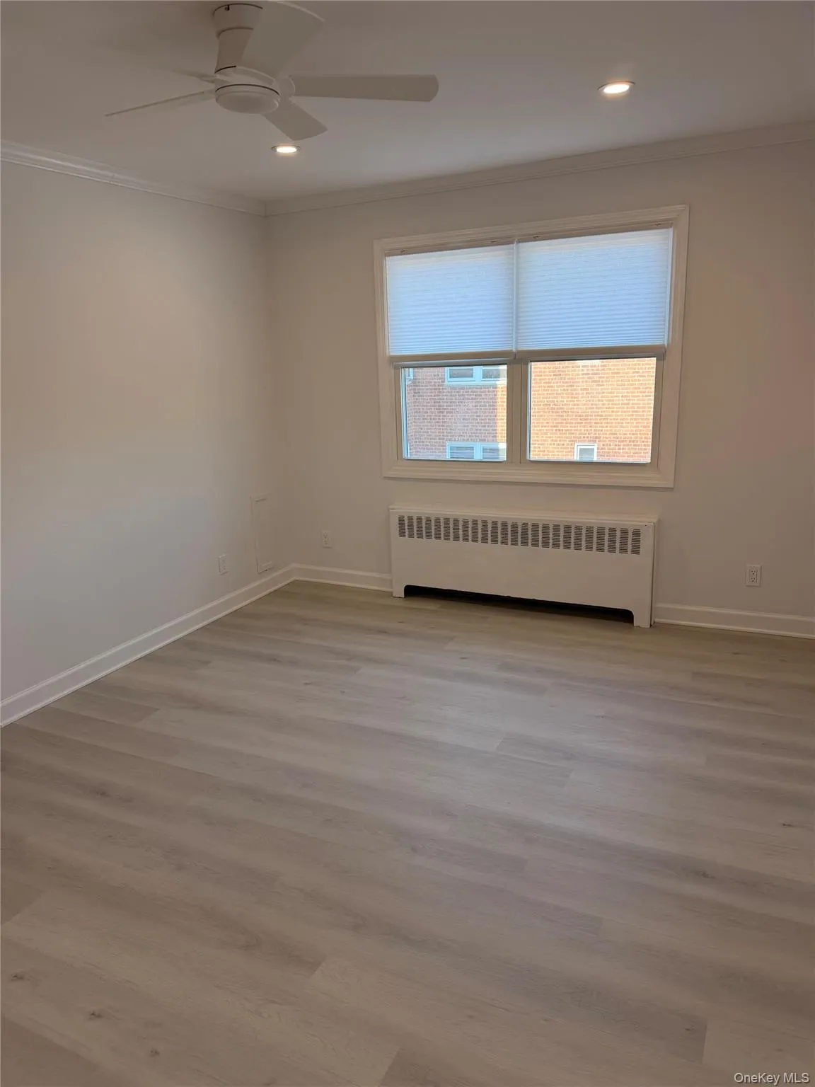 Unfurnished room featuring radiator heating unit, crown molding, a ceiling fan, light wood finished floors, and recessed lighting Unfurnished room featuring radiator heating unit, crown molding, a ceiling fan, light wood finished floors, and recessed lighting