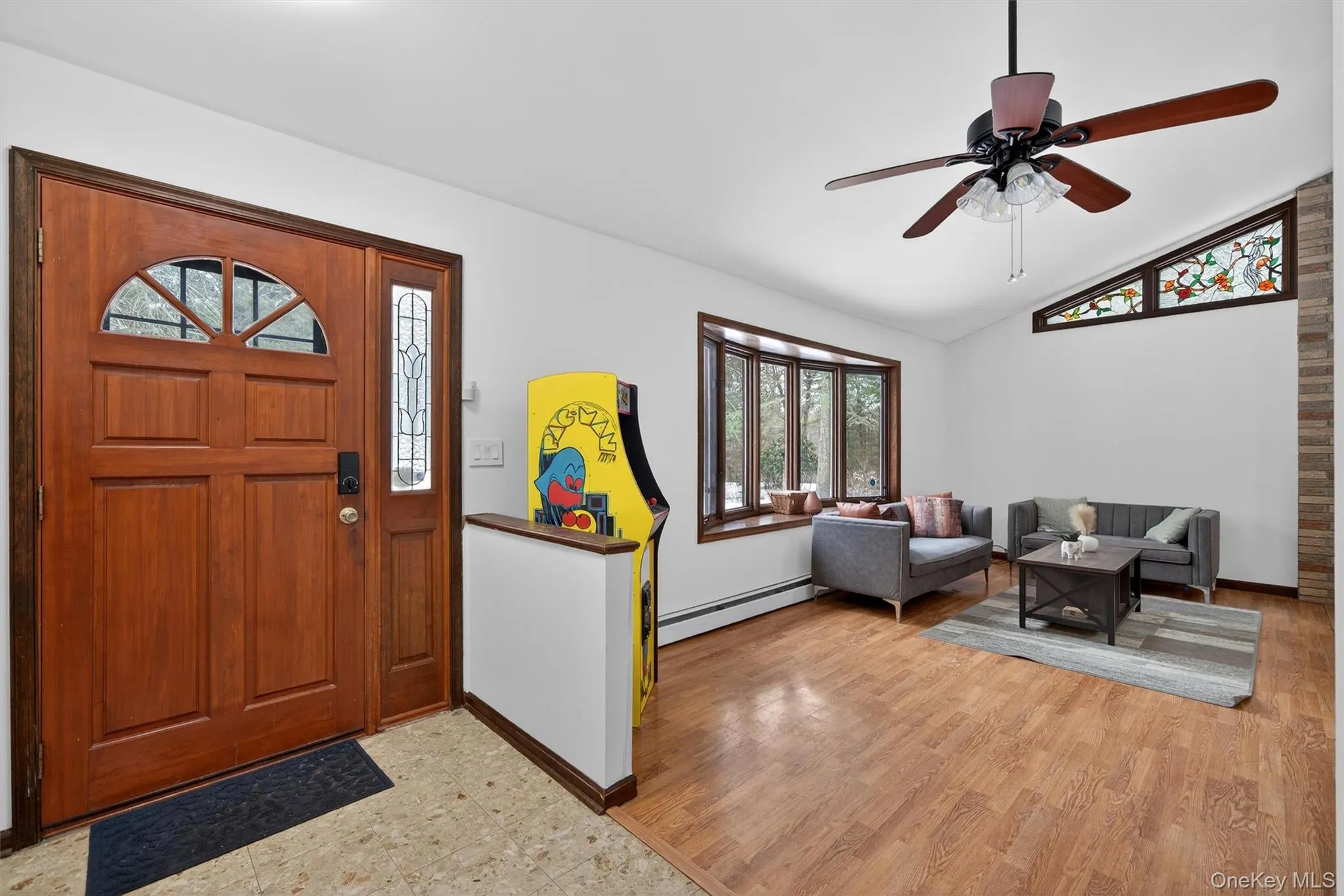 Foyer entrance with ceiling fan, a baseboard heating unit, and vaulted ceiling Foyer entrance with ceiling fan, a baseboard heating unit, and vaulted ceiling